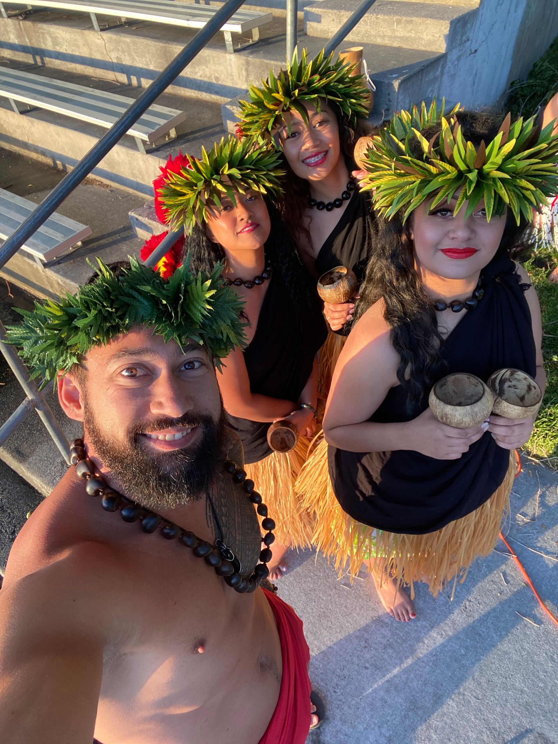 A man and three women are standing next to each other wearing lei.
