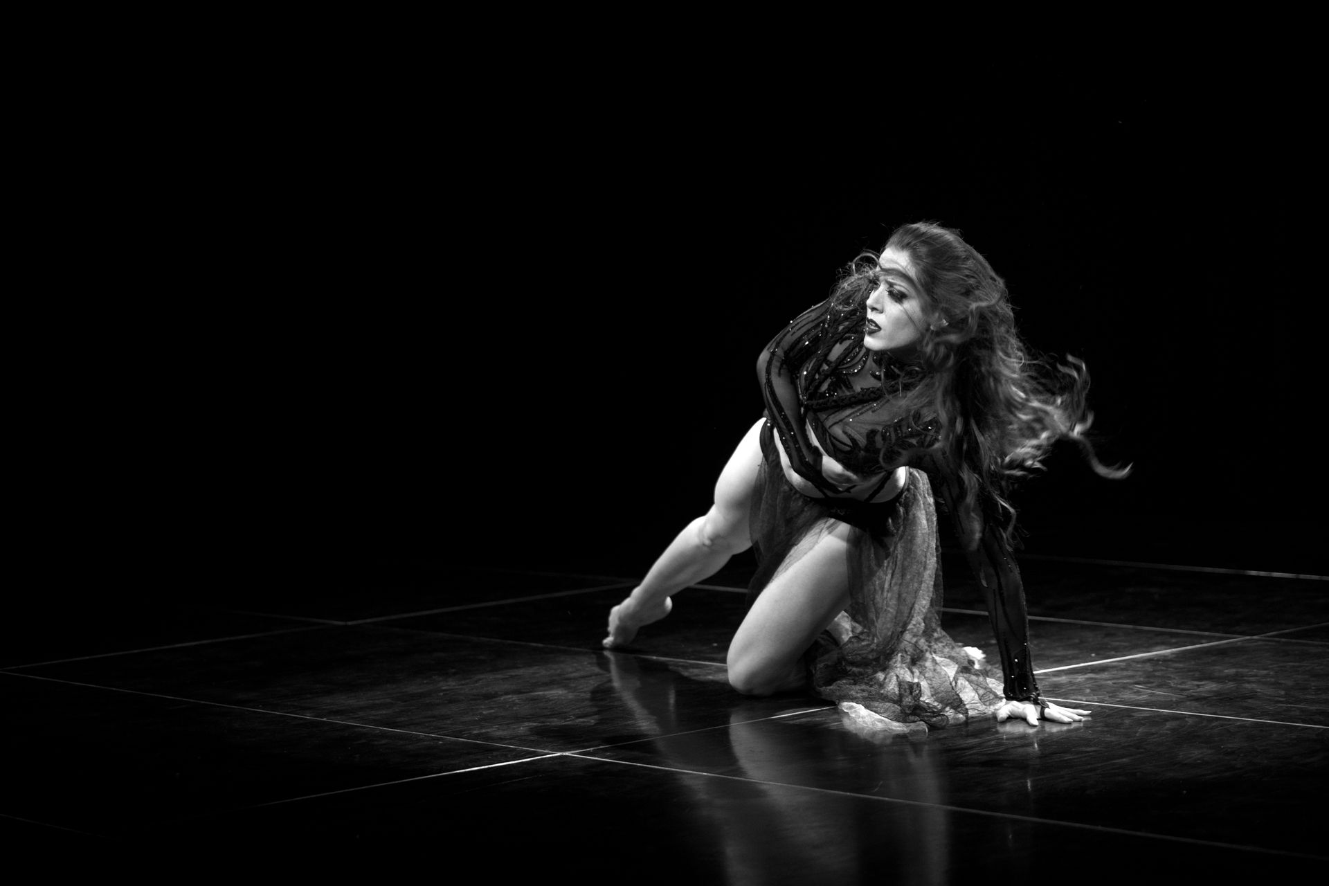 A black and white photo of a woman dancing on a stage.