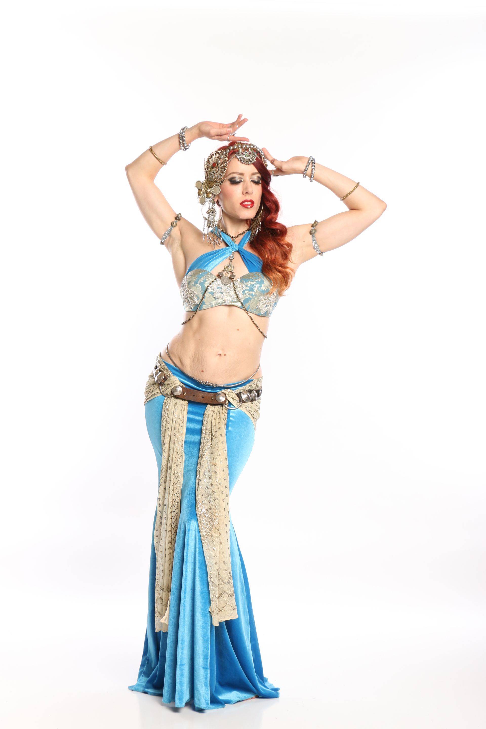 A belly dancer is wearing a blue and gold outfit.