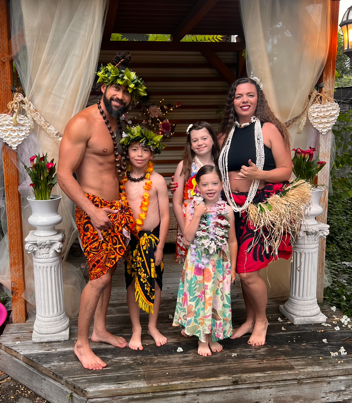 A group of people dressed in hawaiian costumes are posing for a picture.
