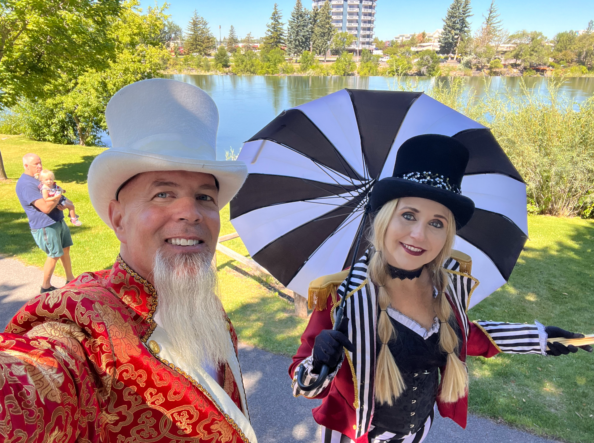 A man and a woman are standing next to each other holding an umbrella.
