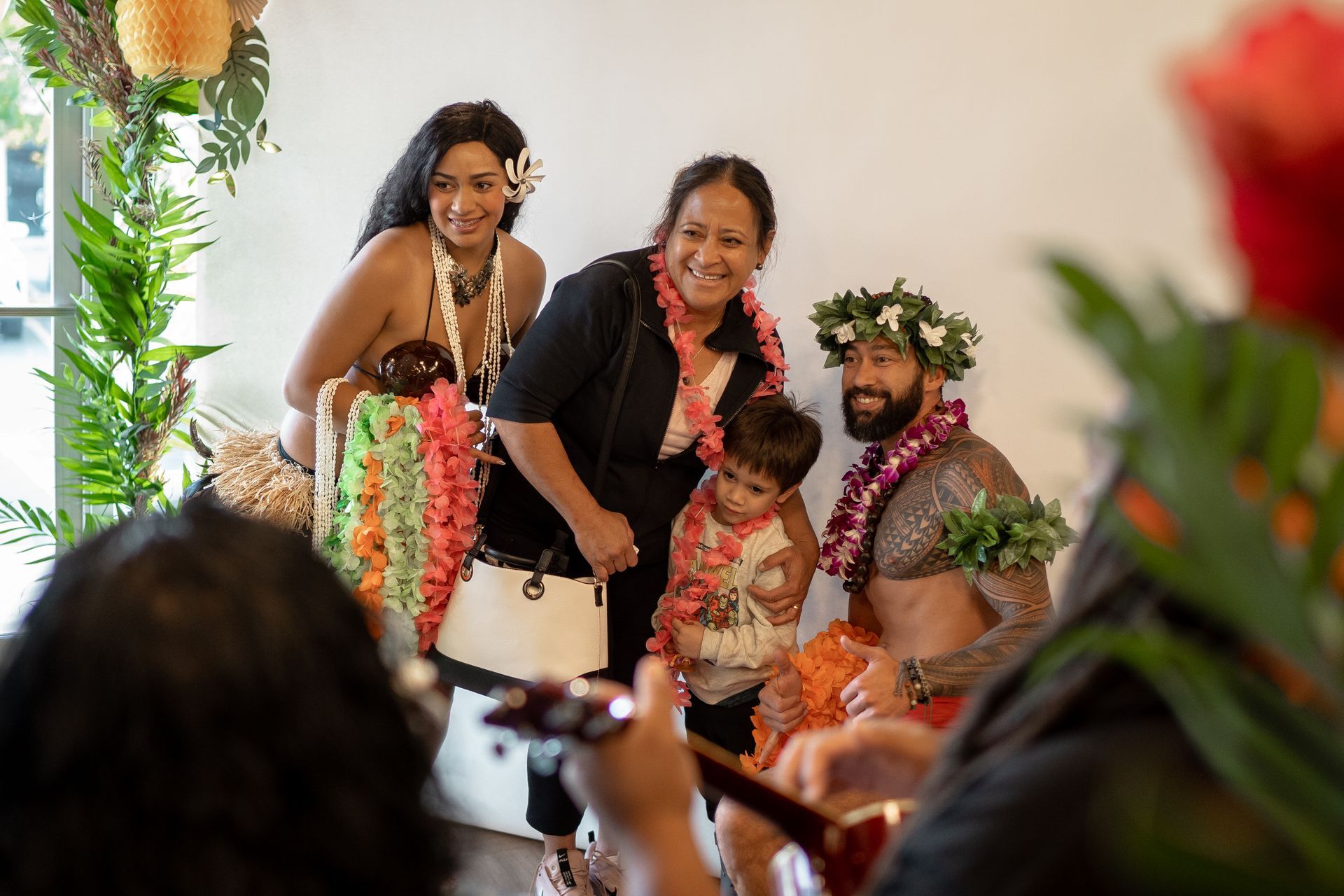 A man is taking a picture of a group of people wearing lei.