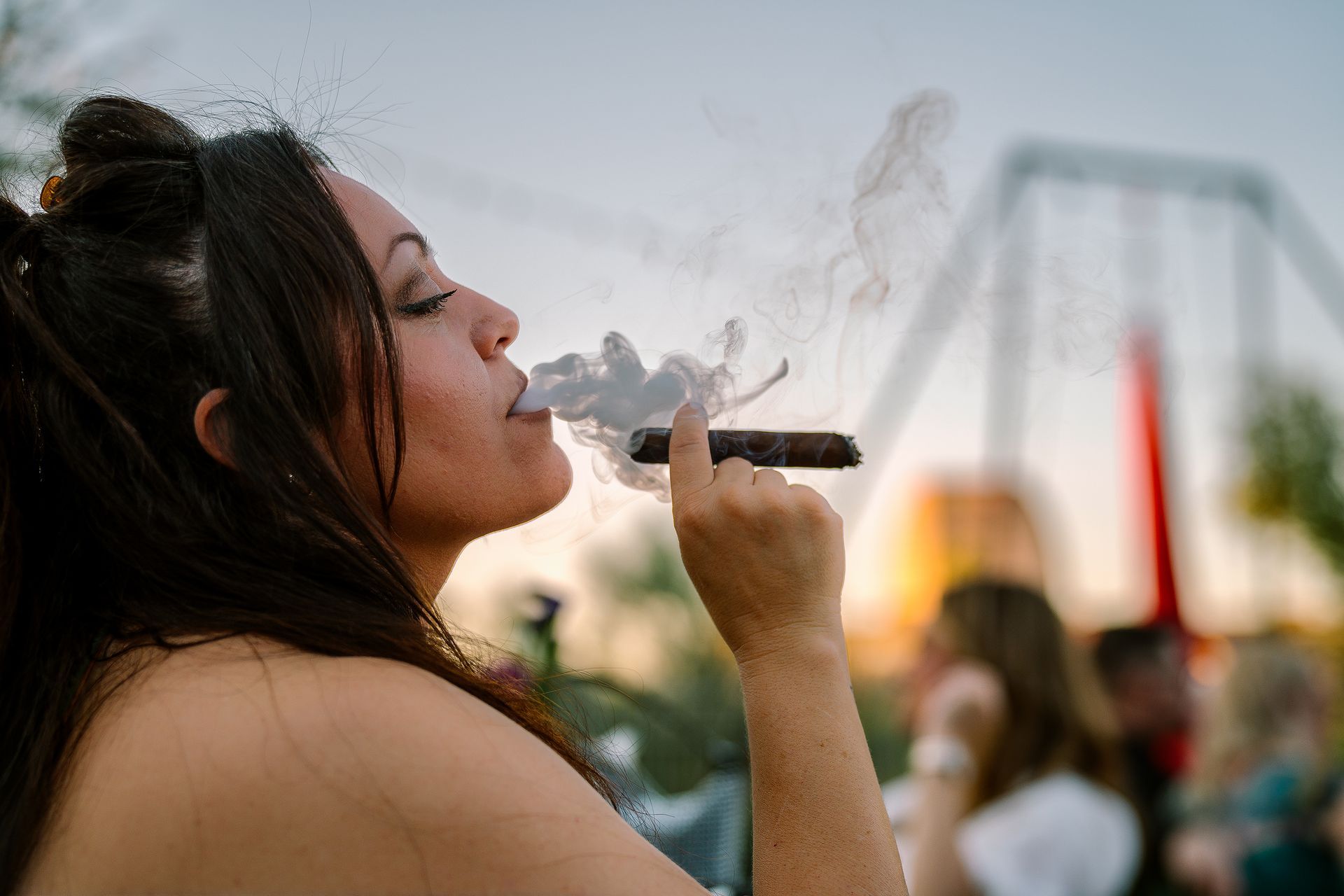 A woman smoking a cigar at a show.