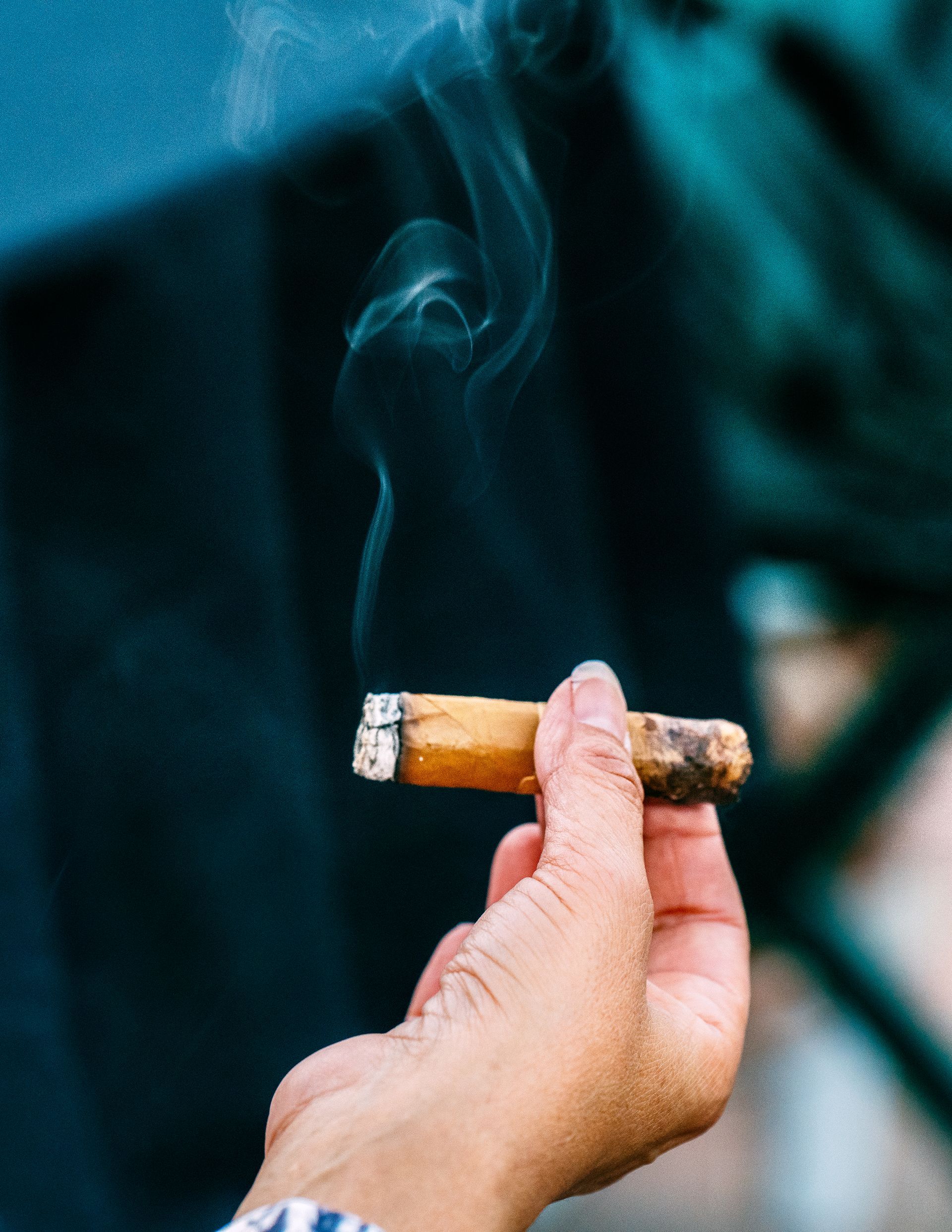 A cigar being held by two fingers.
