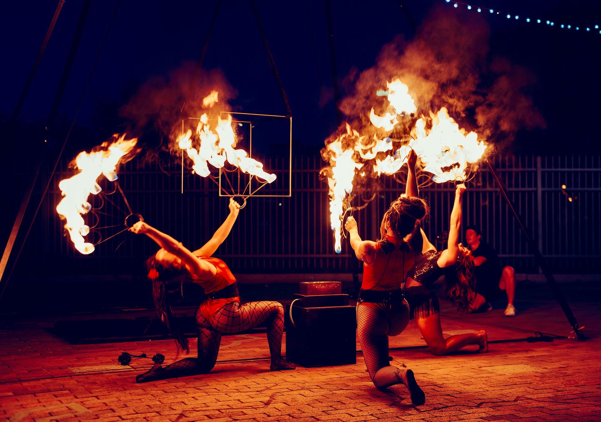 Two women are performing a fire show at night.