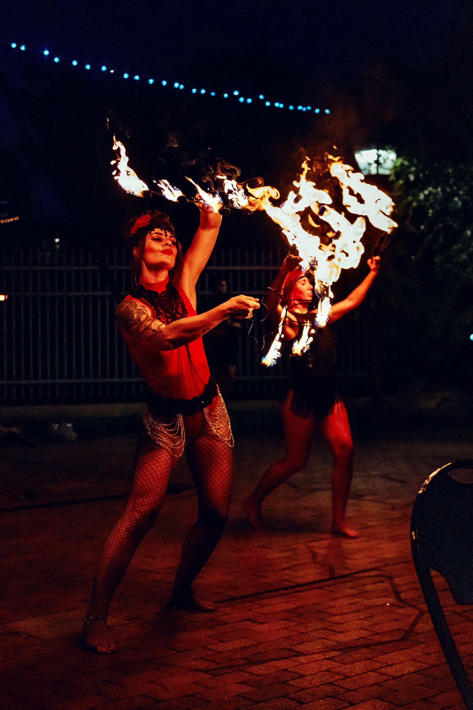 Two women are dancing with fire in their hands