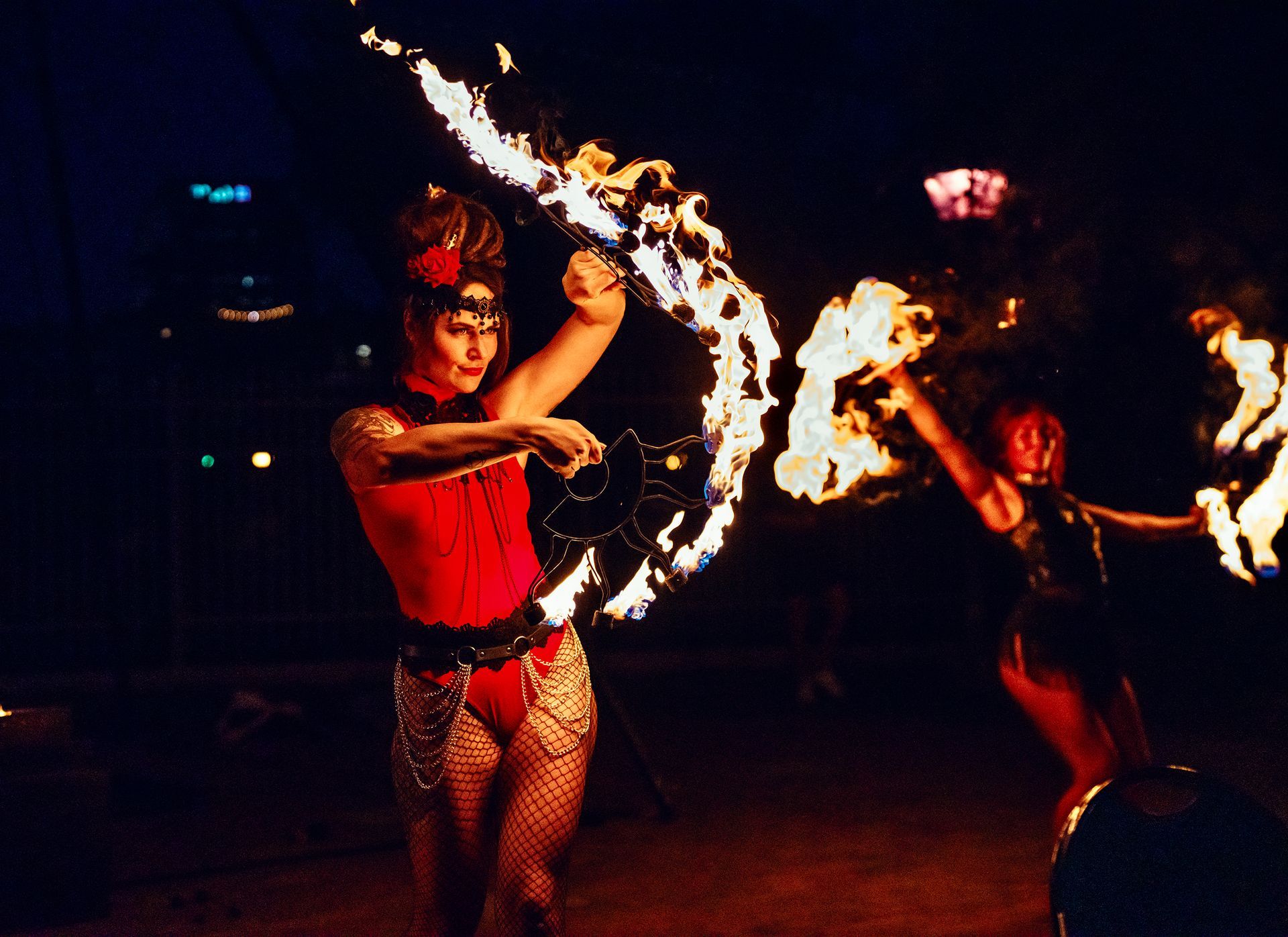 A woman in a red top is holding a fire ring