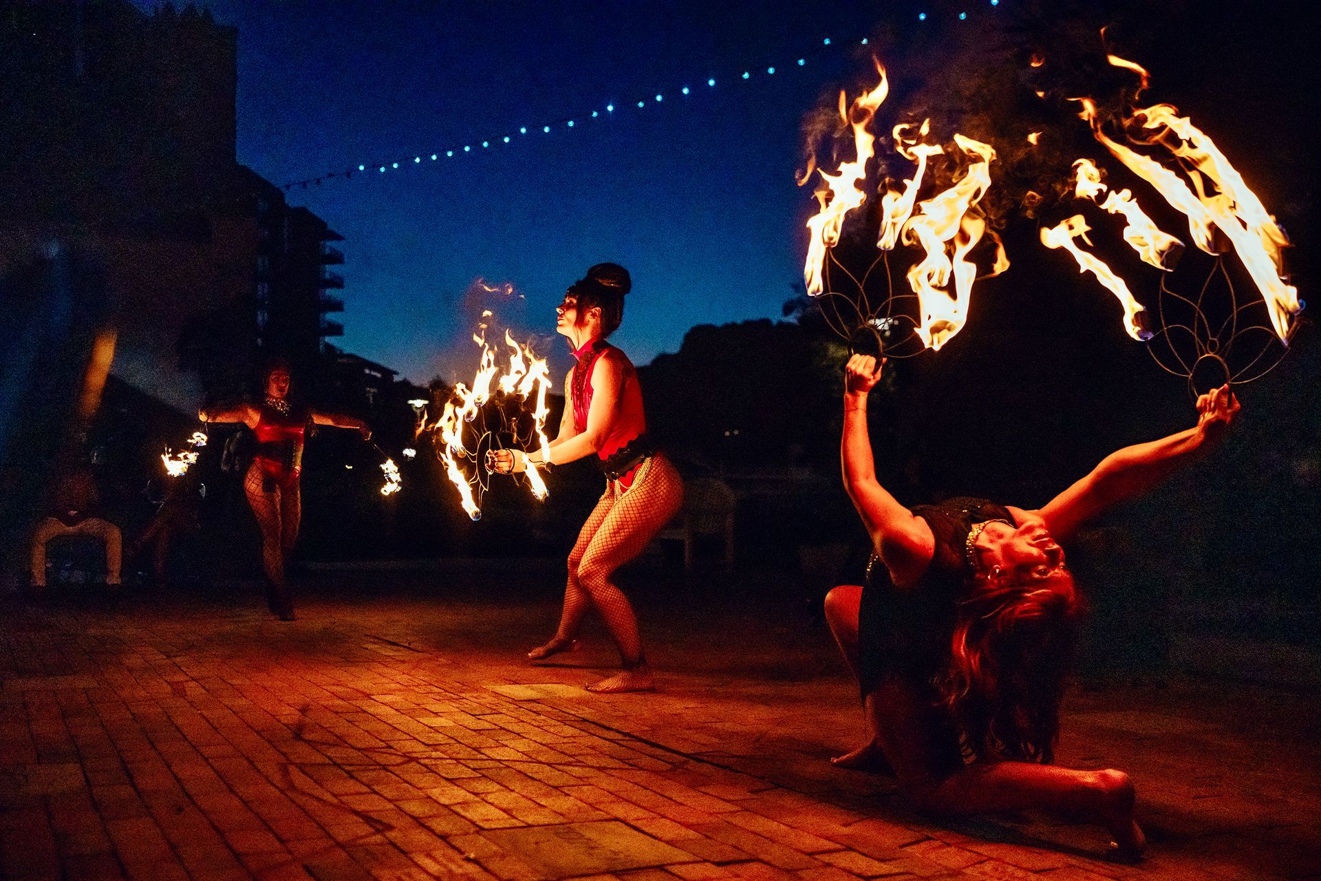 A group of people are performing a fire show at night
