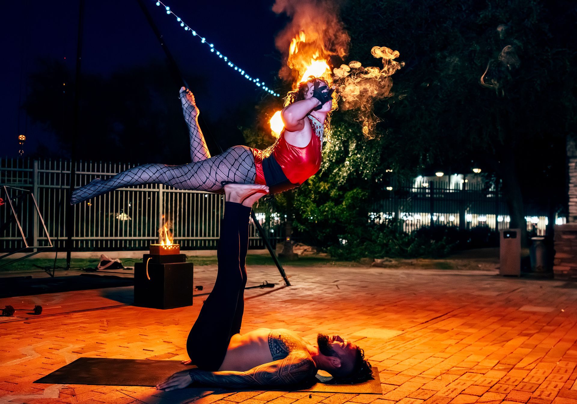 A man is holding a woman up in the air while she is on his shoulders.