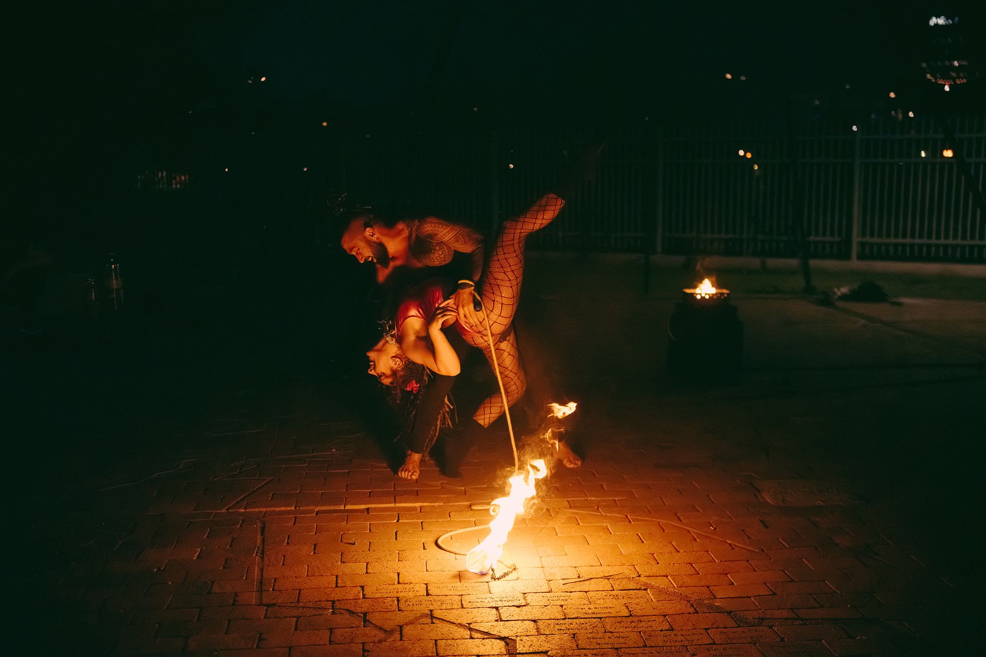 A group of people are standing around a fire at night.