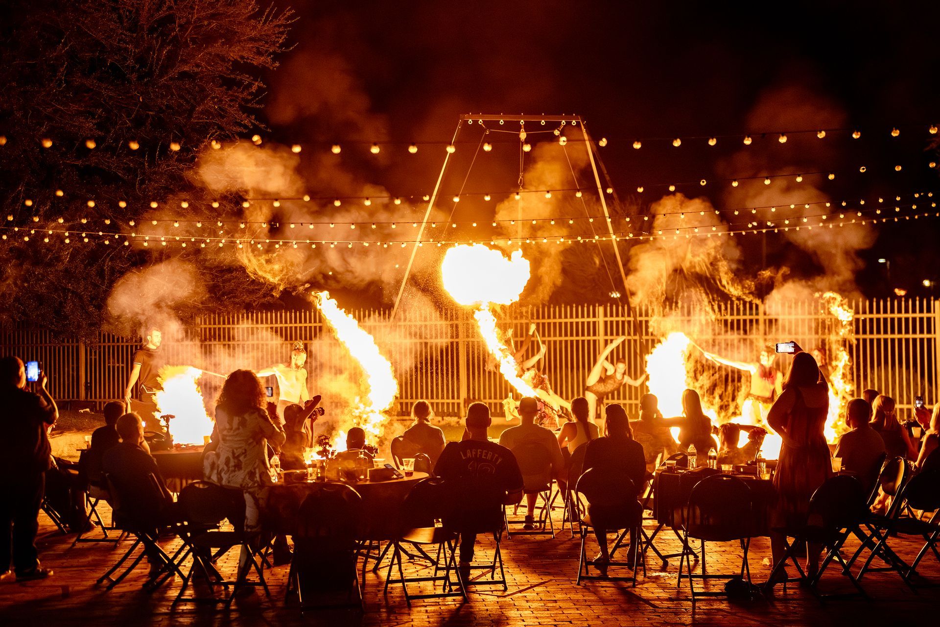 A group of people are sitting around a fire at night.