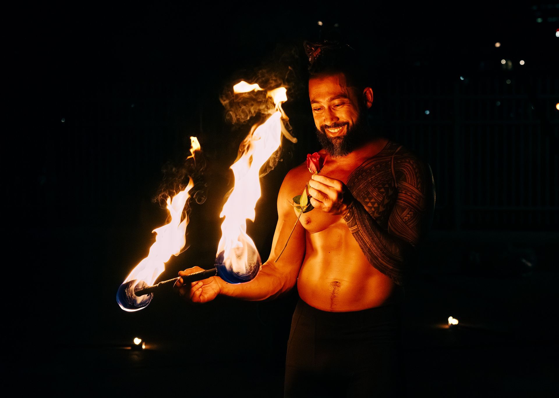 A shirtless man is holding a torch with flames coming out of it.