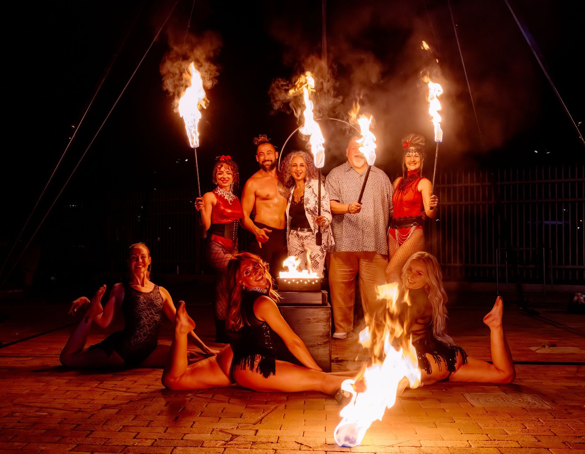 A group of people are posing for a picture with fire torches.