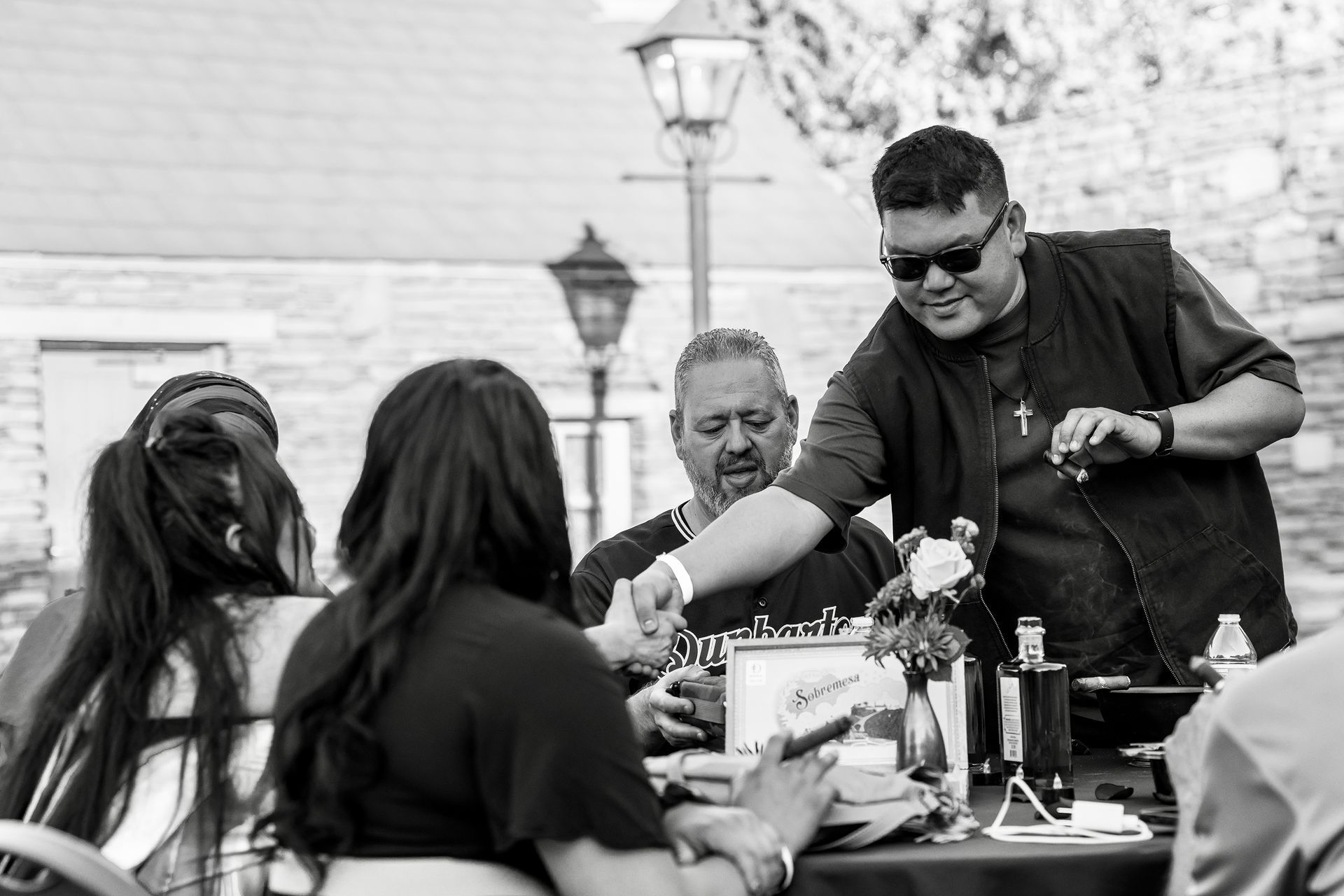 A black and white photo of a group of people sitting at a table.