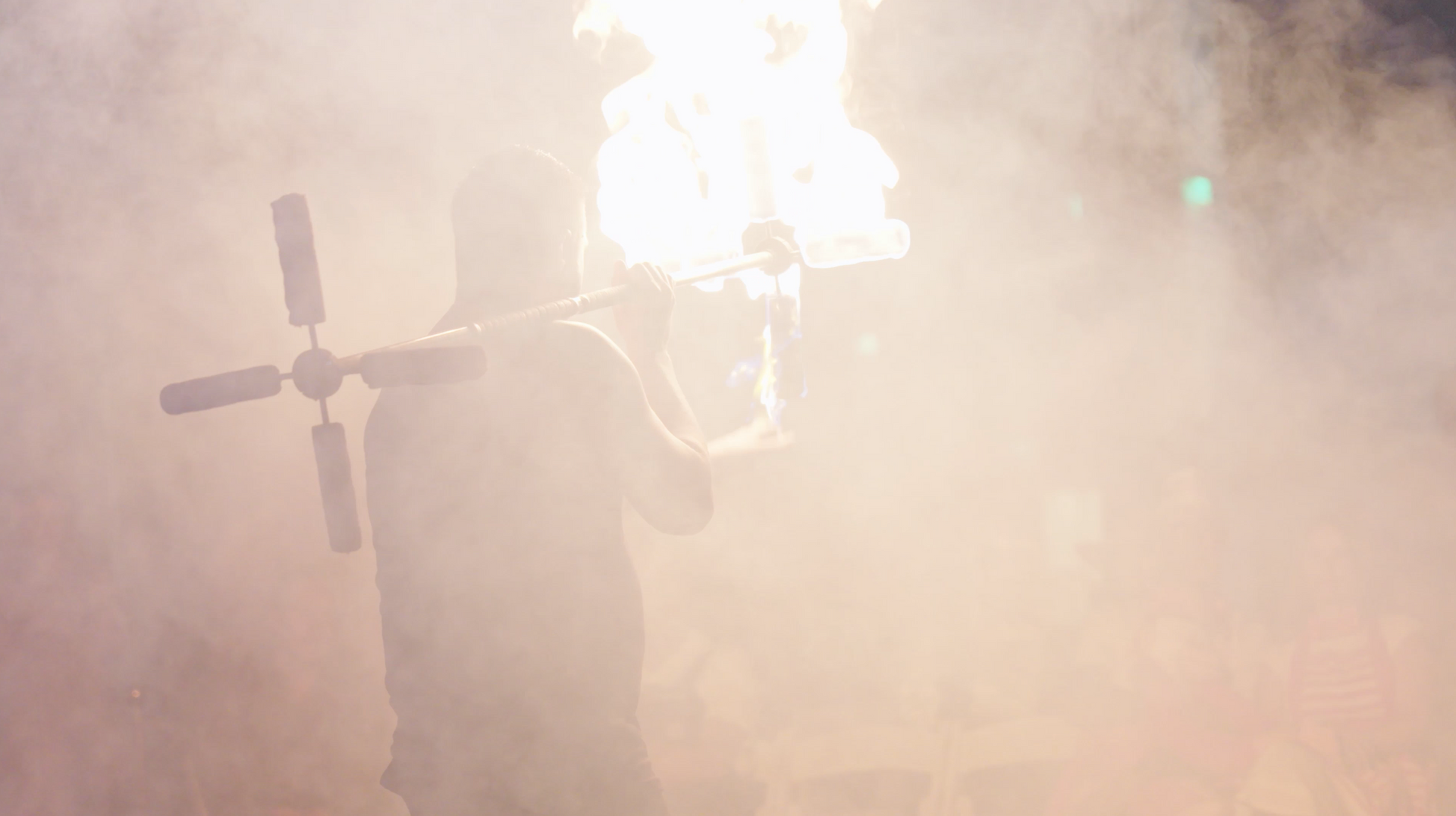 A man is holding a fan with flames coming out of it.