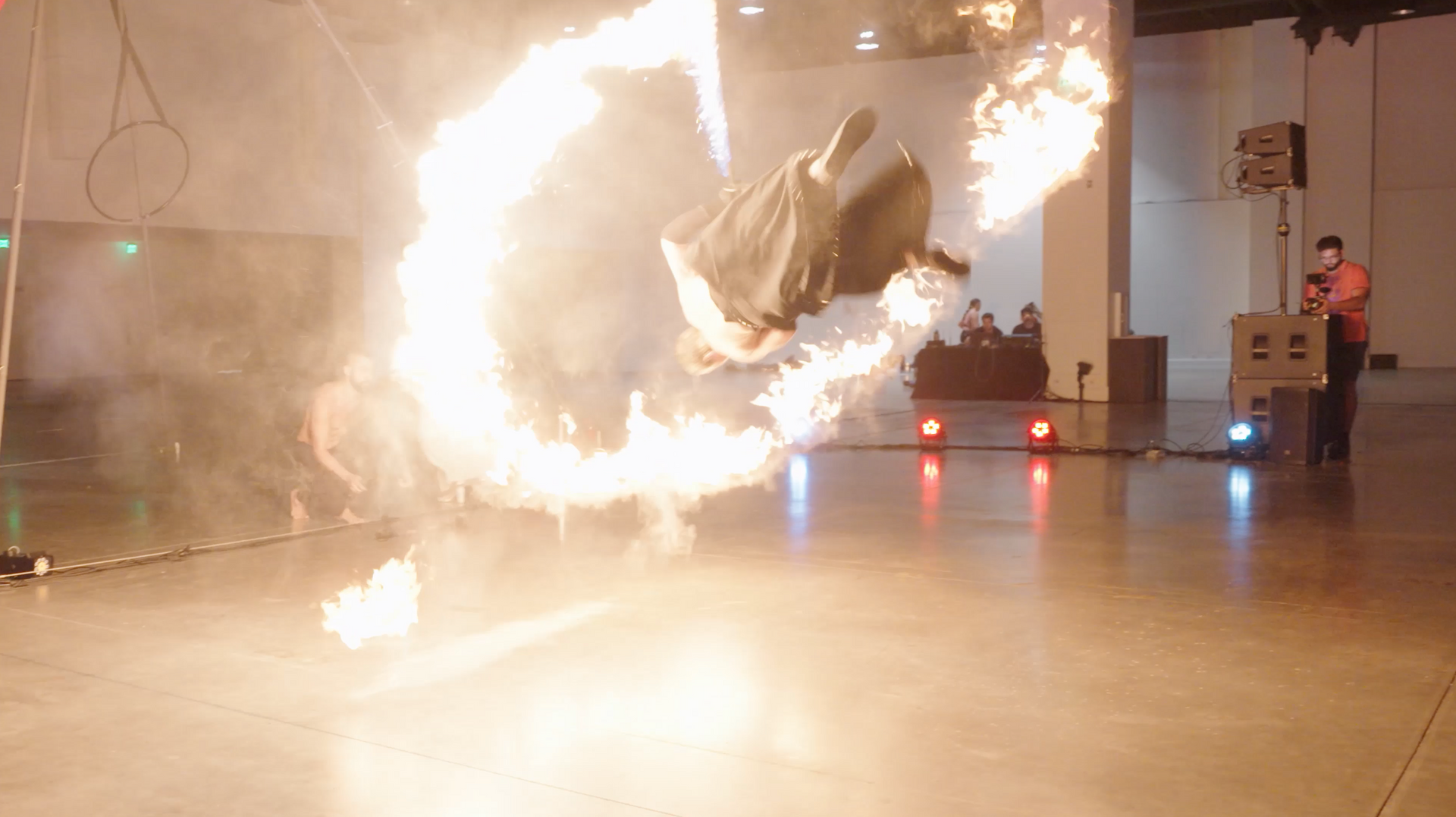 A person is doing a trick with fire in a room.