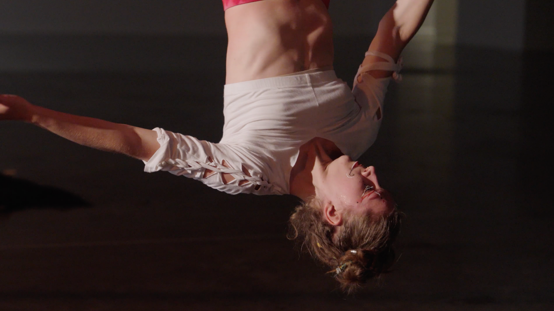 A woman is doing a handstand in a dark room.