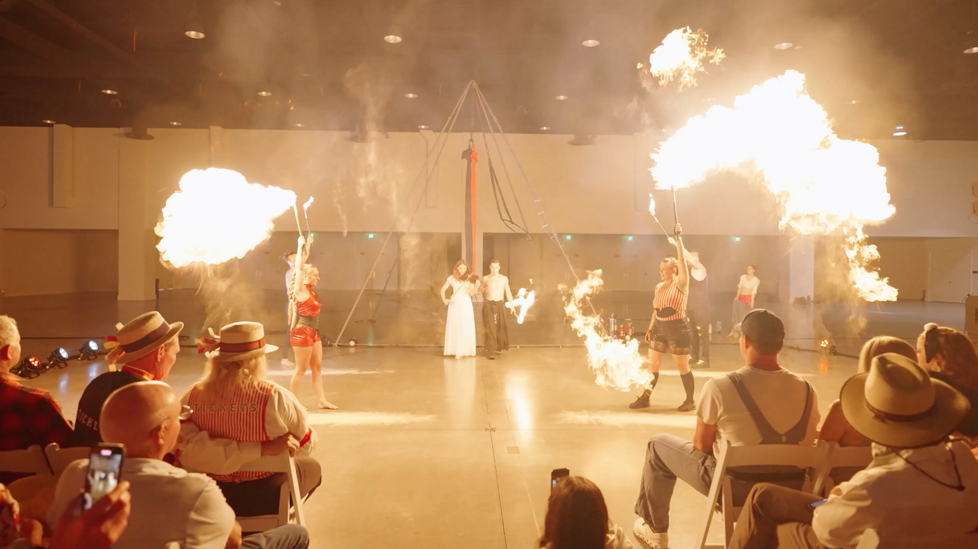 A group of people are sitting in chairs watching a fire show.