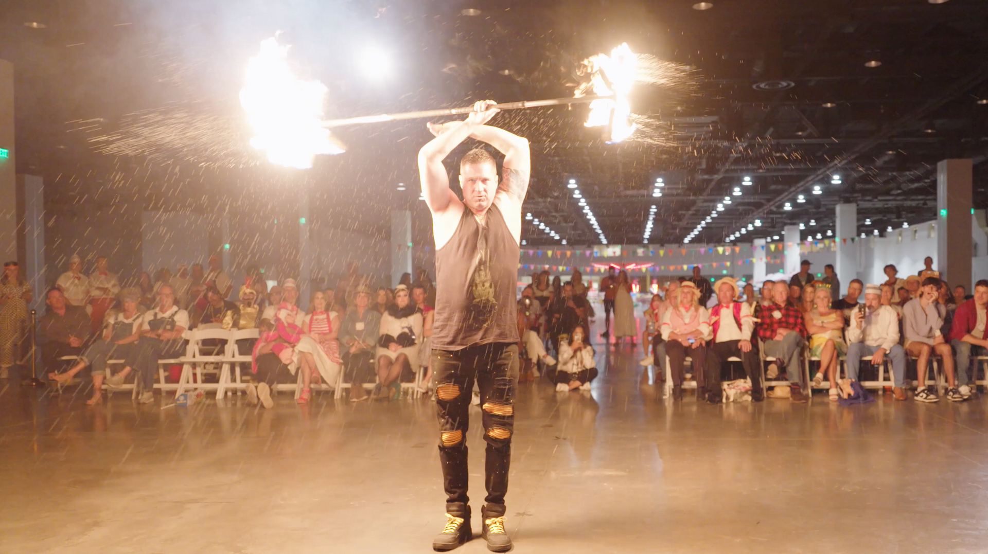 A man performing dragon staff in front of a crowd.
