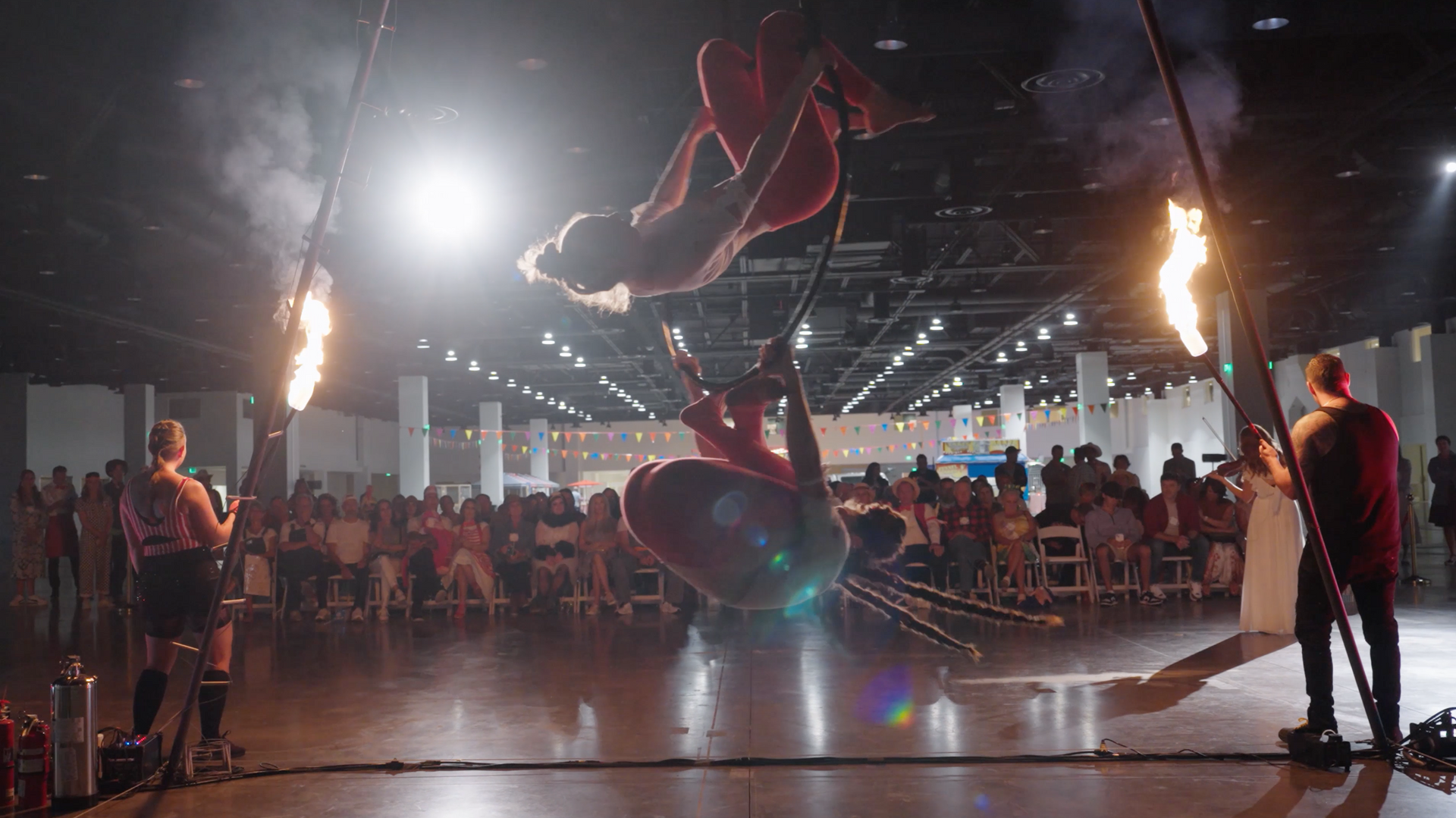 A group of people are performing aerial acrobatics in front of a crowd.