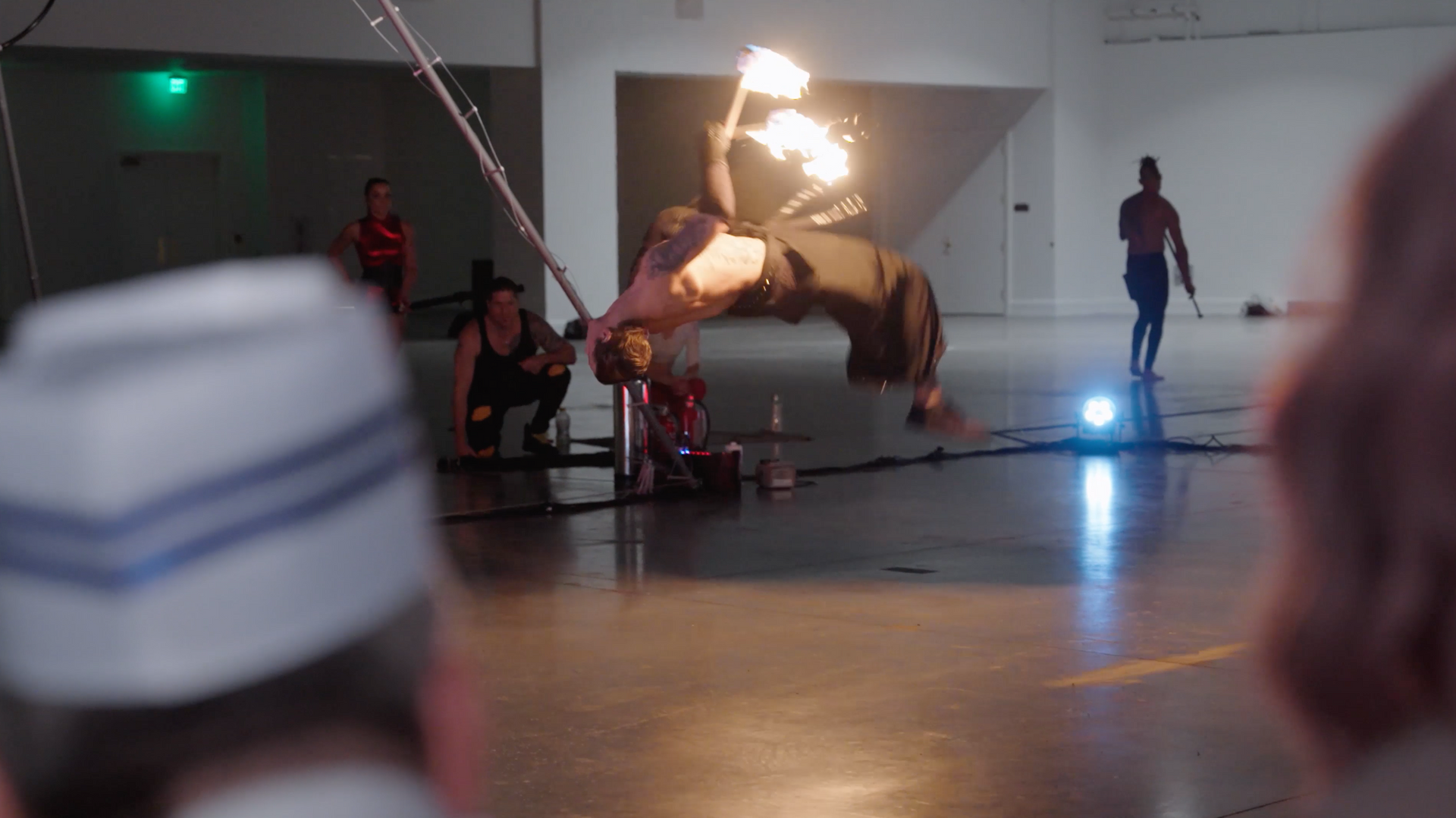 A group of people are watching a man do a trick with fire.