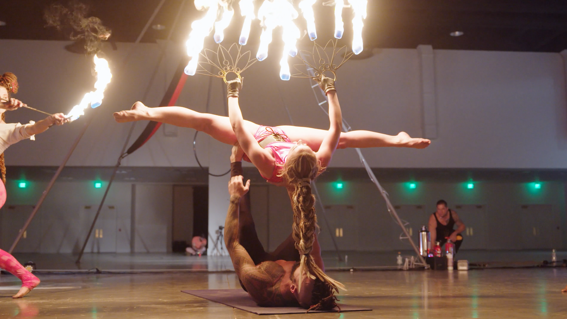 A group of people are performing aerial acrobatics in a gym.