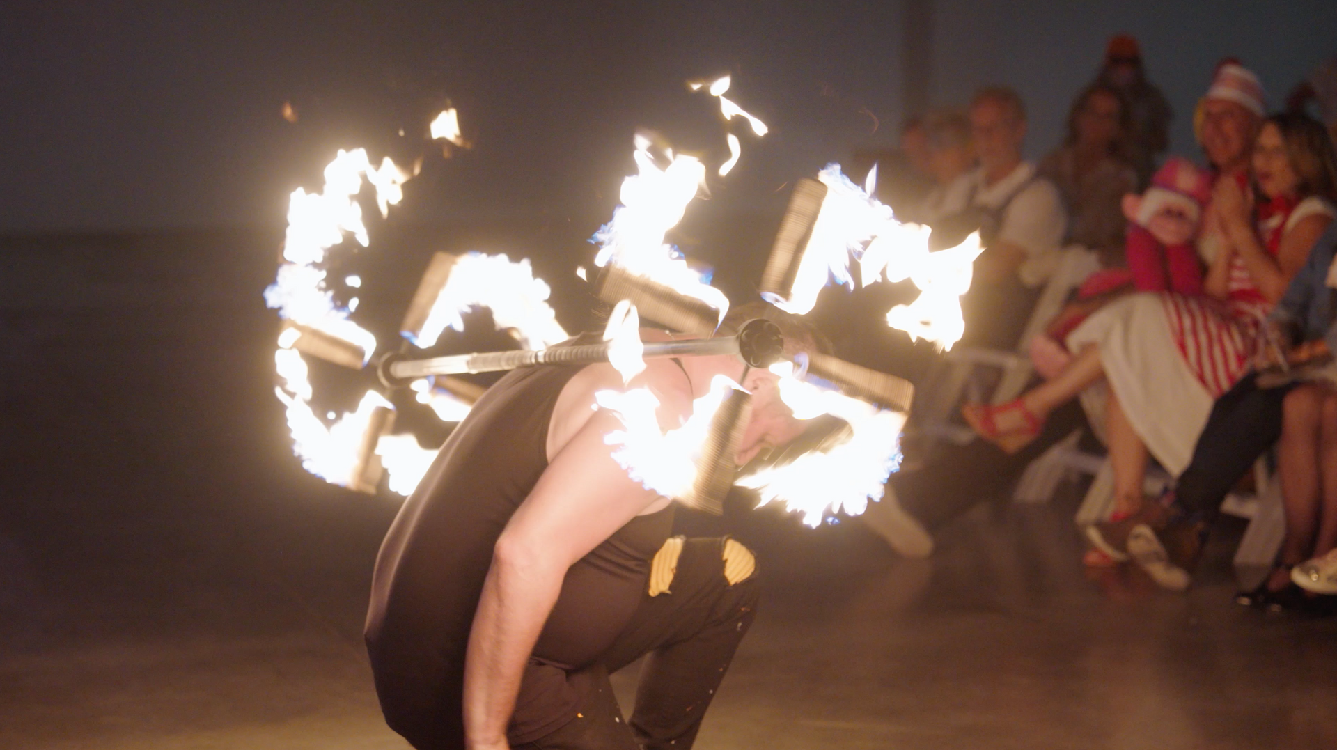 A man is performing a fire show in front of a crowd of people.