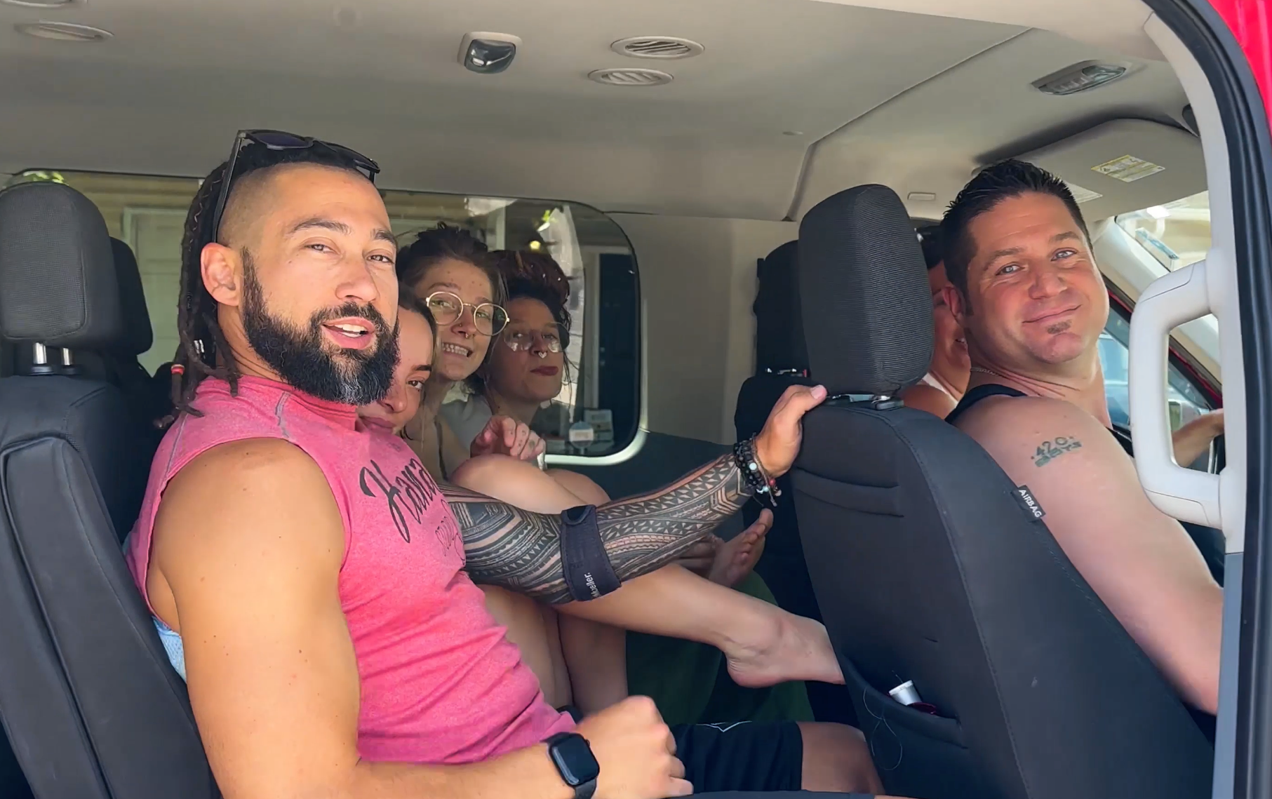 A group of people are sitting in the back seat of a car.