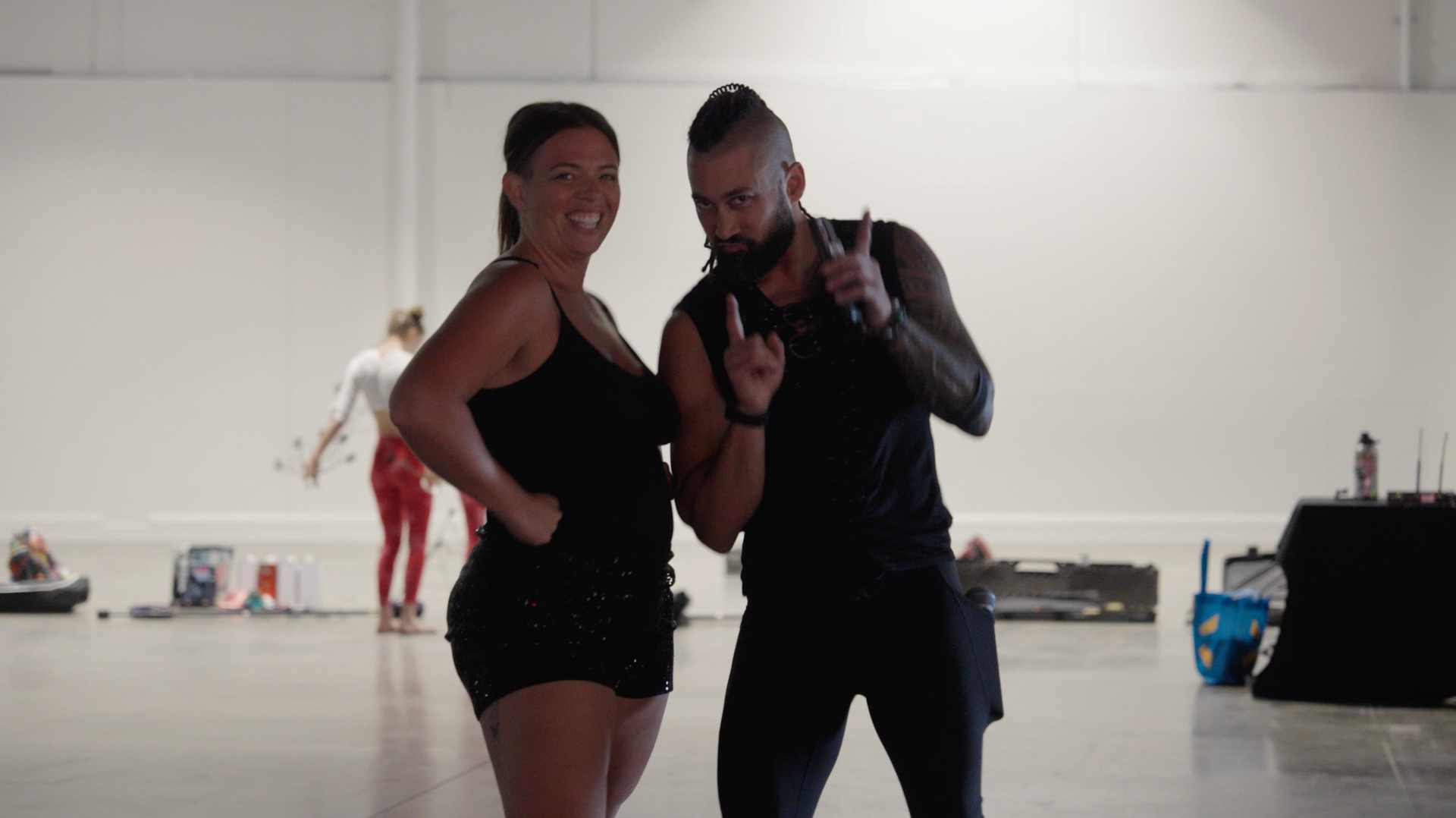 A man and a woman are standing next to each other in a gym.