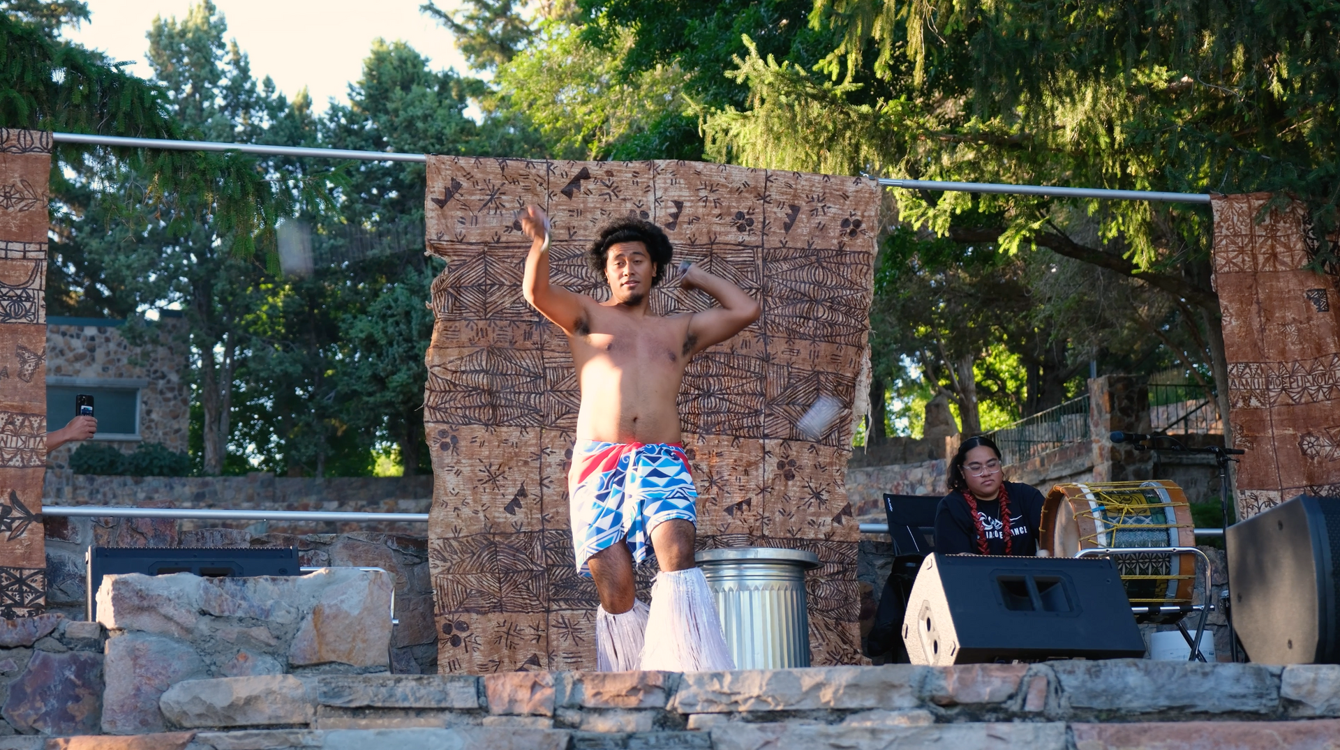 A man without a shirt is dancing on a stage