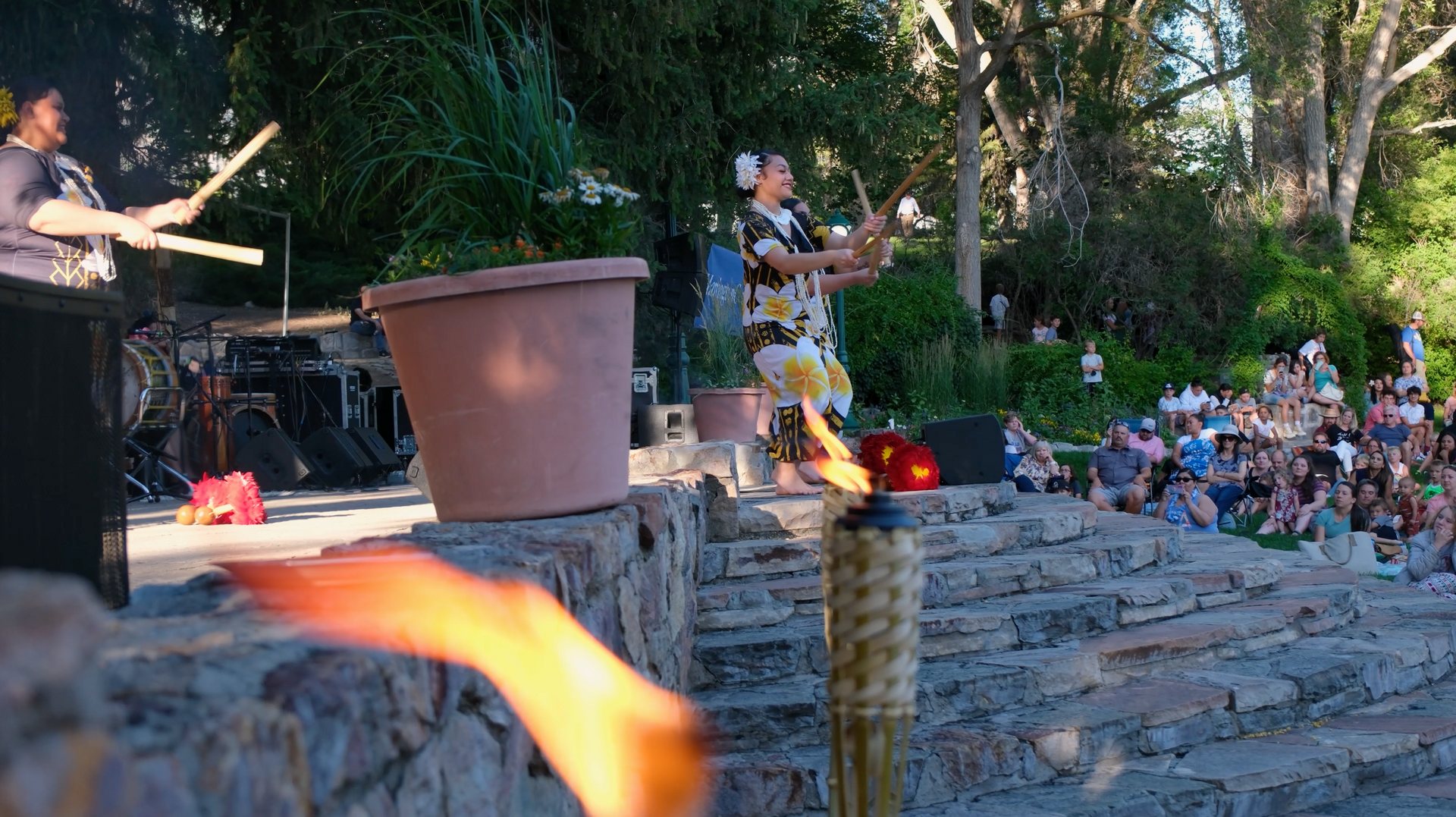 A woman is holding a torch in front of a crowd of people.