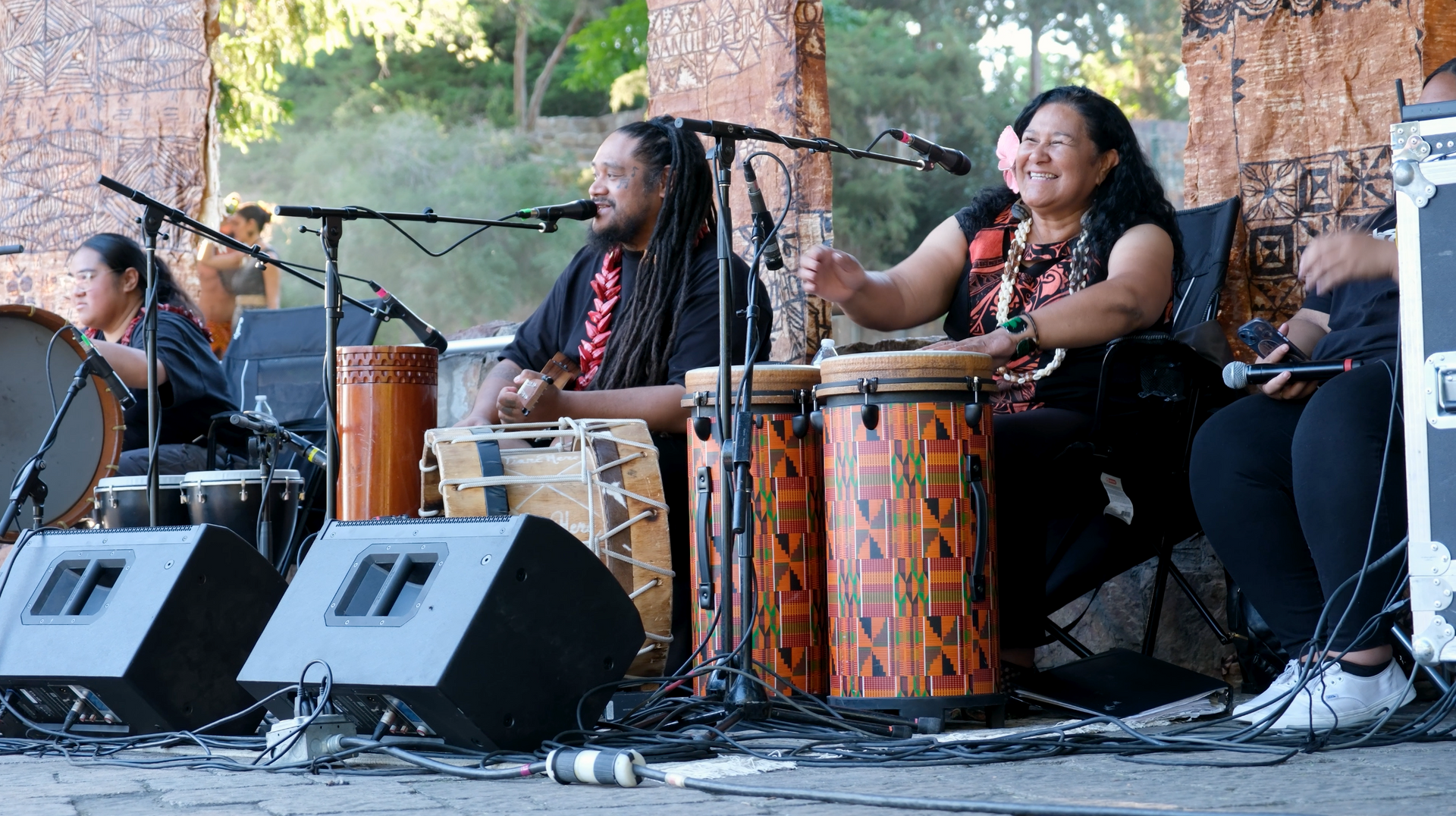 A group of people are playing drums on a stage.