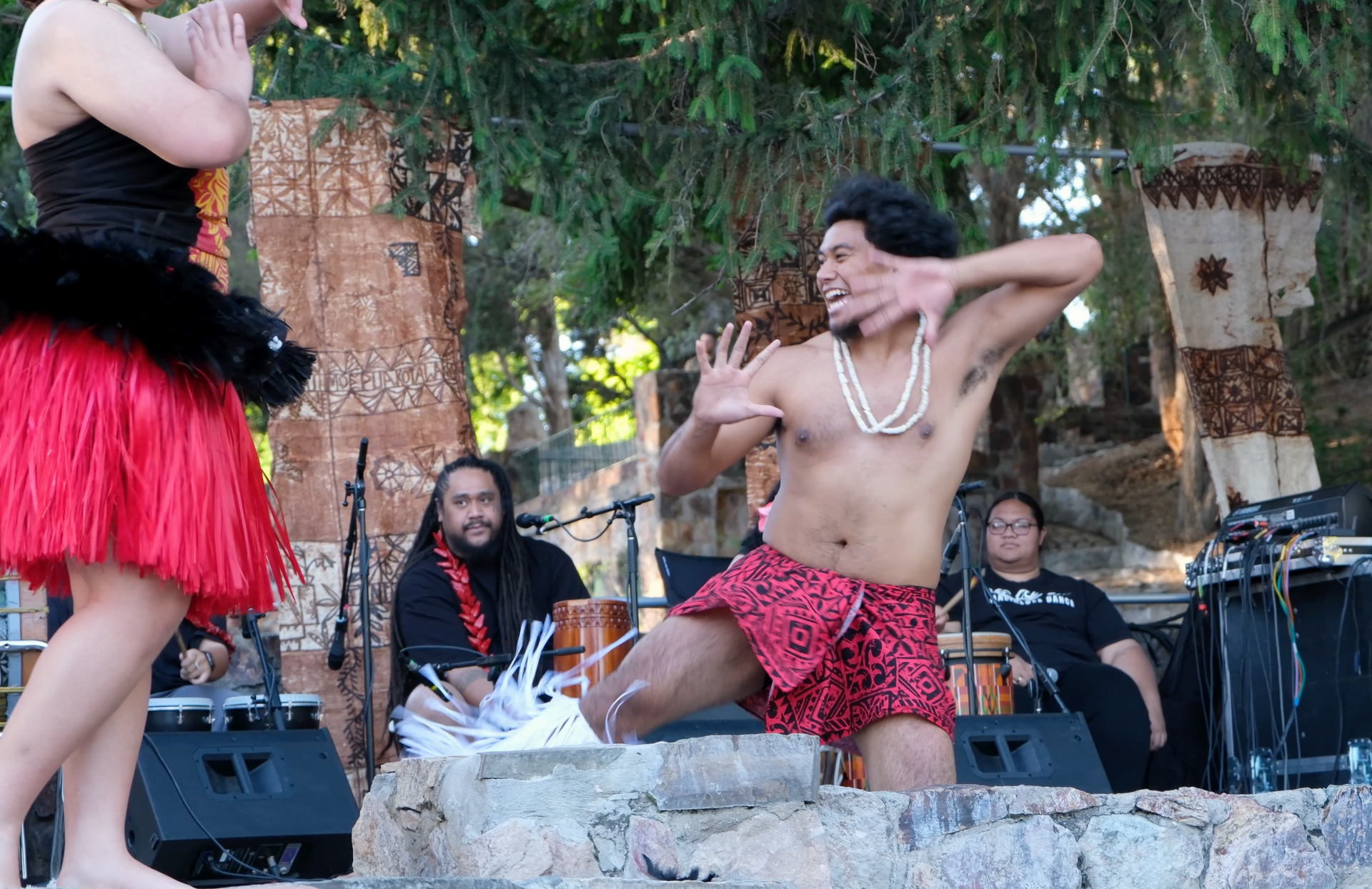 A man without a shirt is dancing in front of a group of people