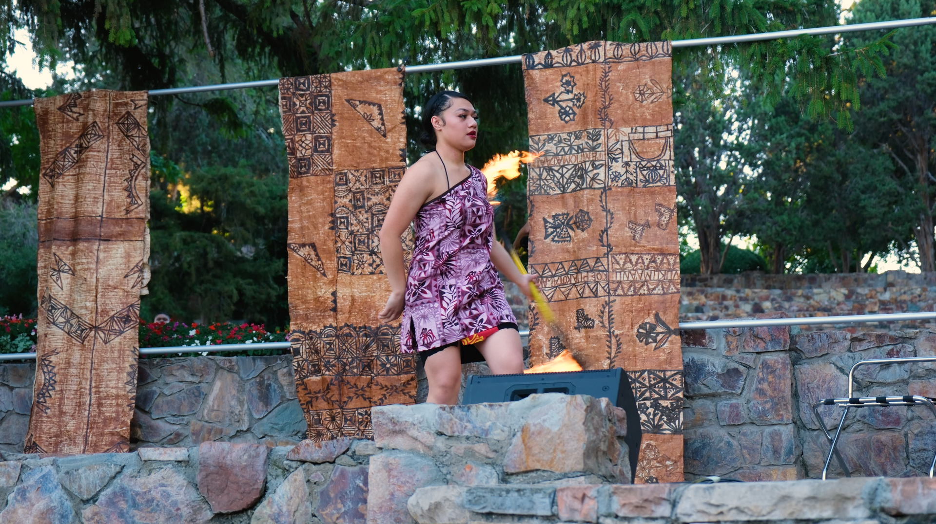 A woman in a purple dress is holding a torch