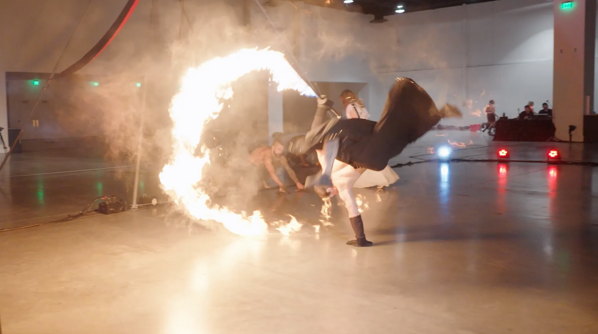 A person is doing a handstand in front of a circle of fire.