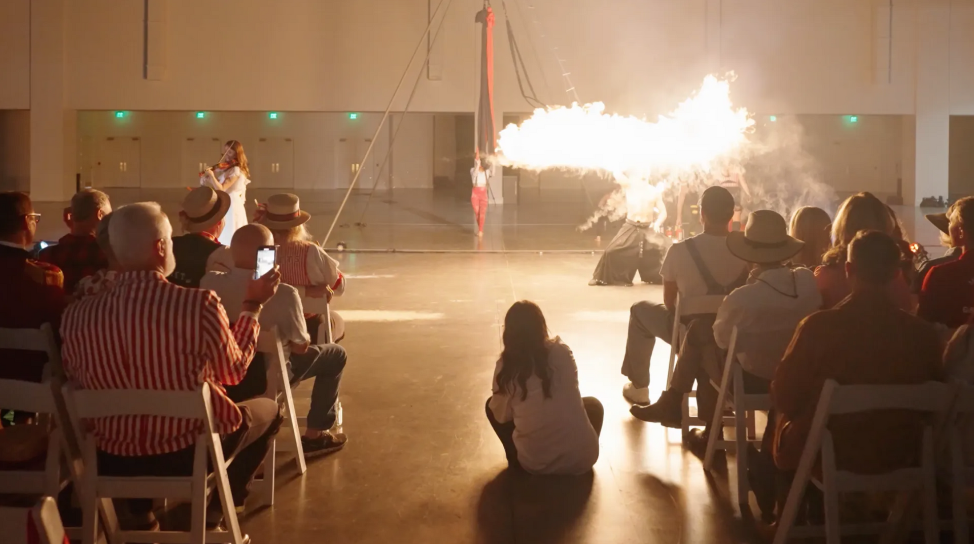 A group of people are sitting in chairs watching a fireworks display.