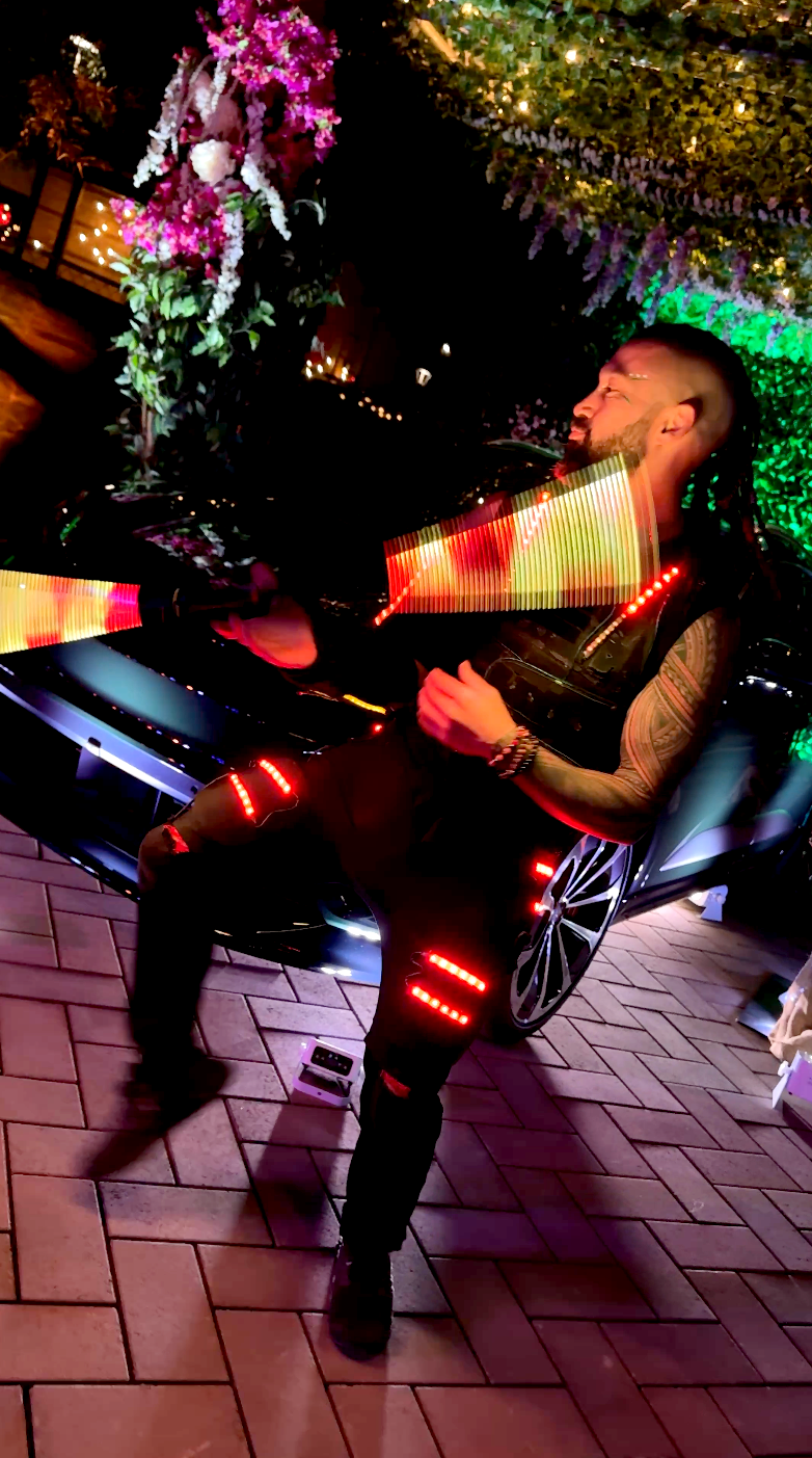A man is sitting on a bench with a bottle of wine in his hand.