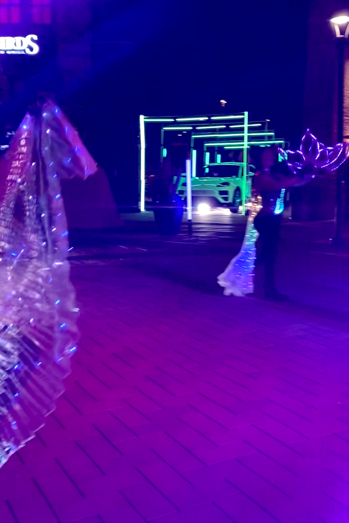 A couple is dancing in a dark room with purple lights.