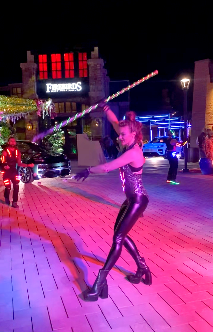 A woman is holding a hula hoop in front of a building.