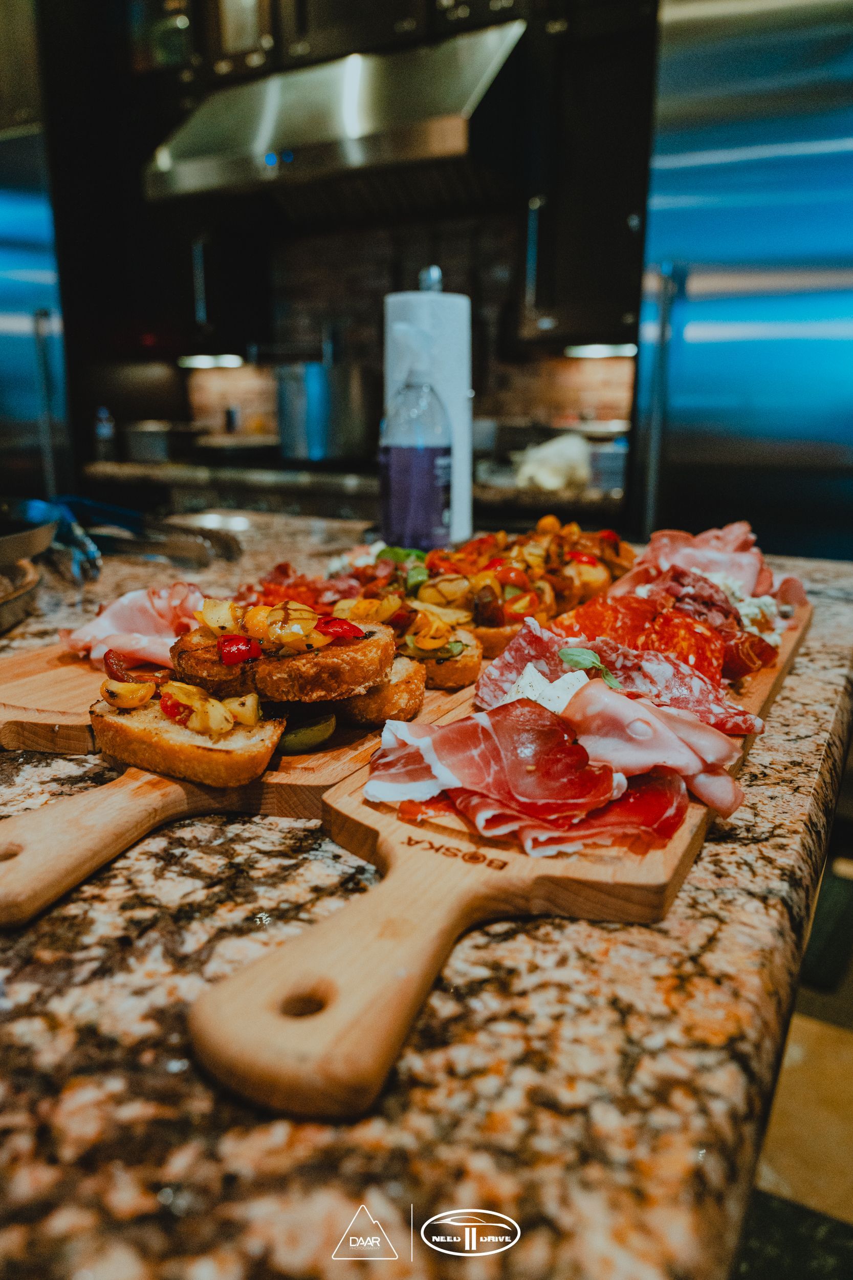 A wooden cutting board filled with different types of food on a counter.