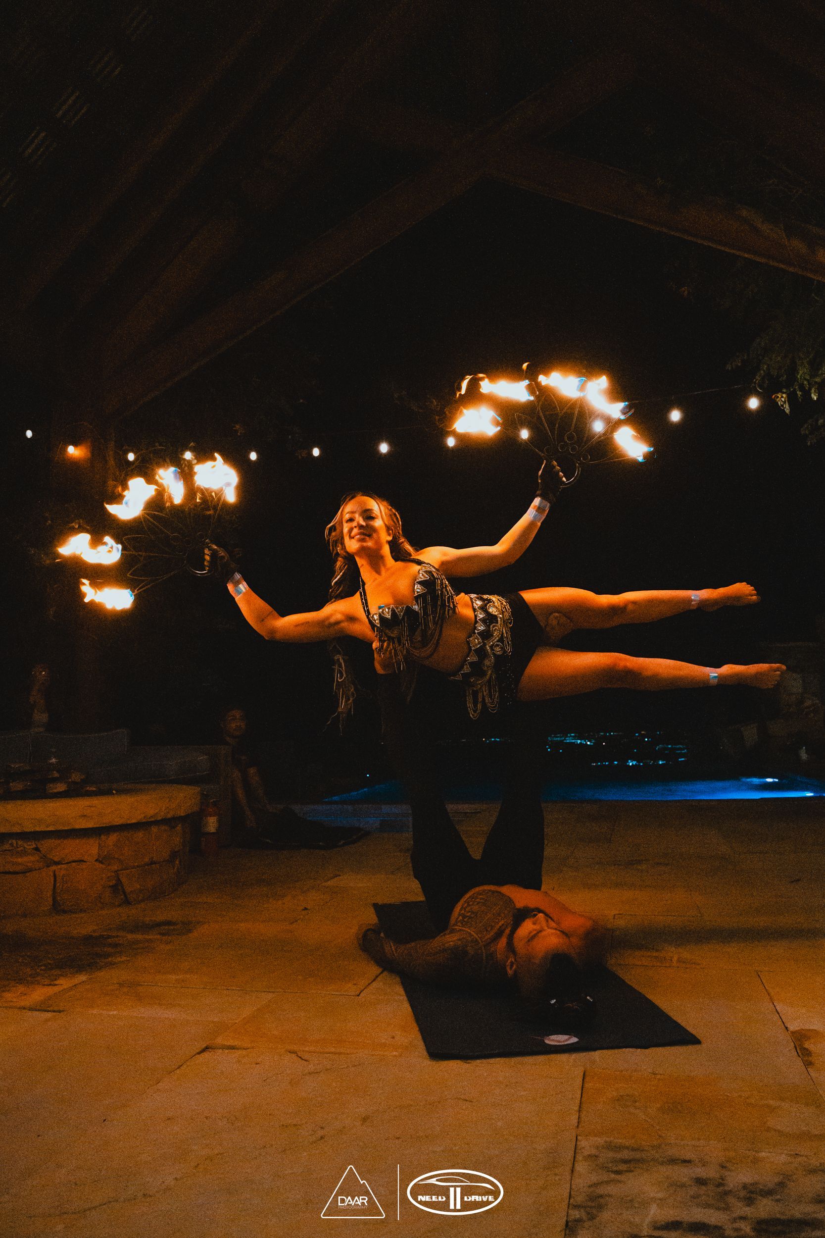 A man and woman performing acrobatic fire.