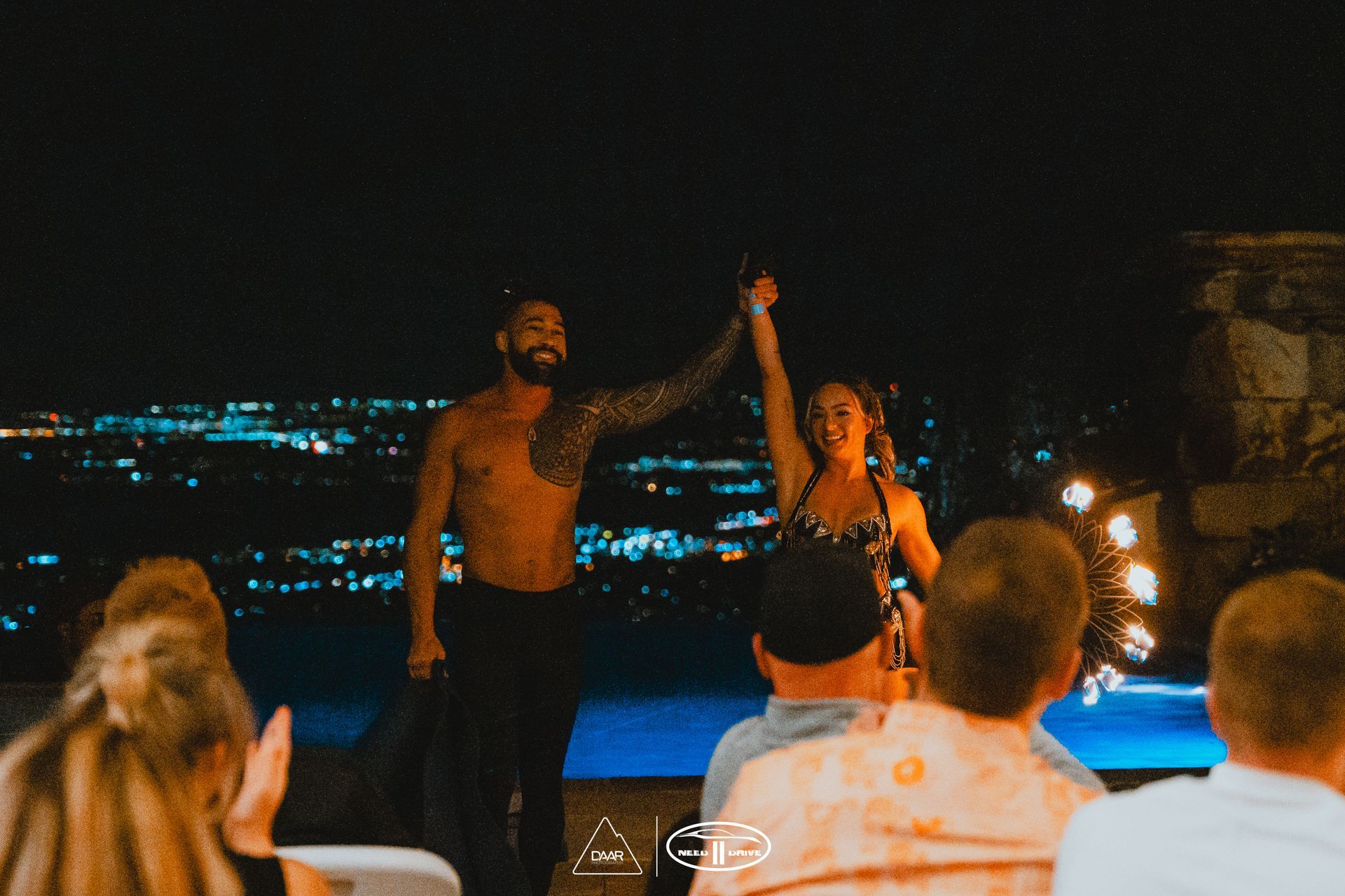 A man and a woman are holding hands in front of a crowd of people.