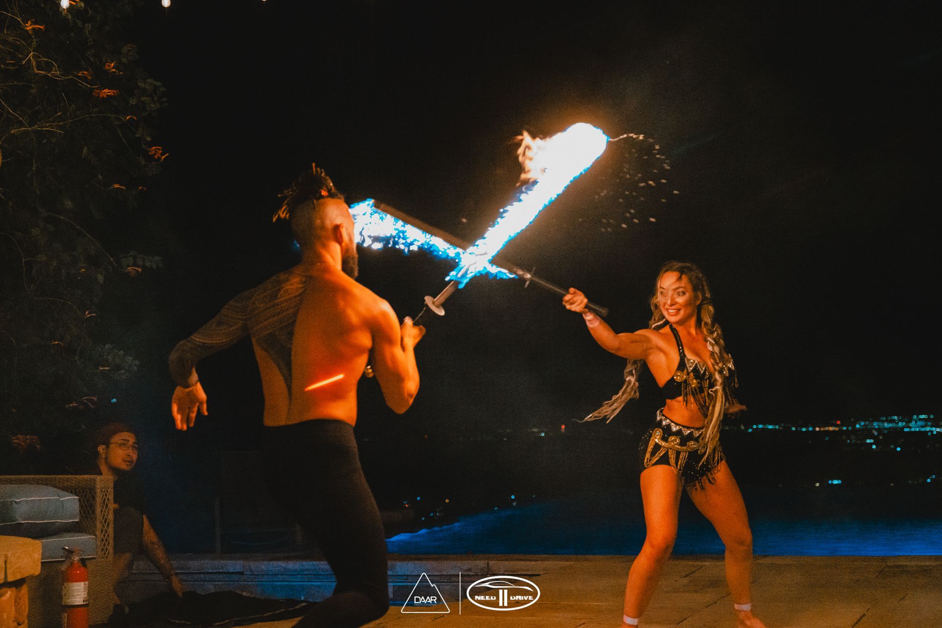 A man and a woman are holding fire swords in their hands.