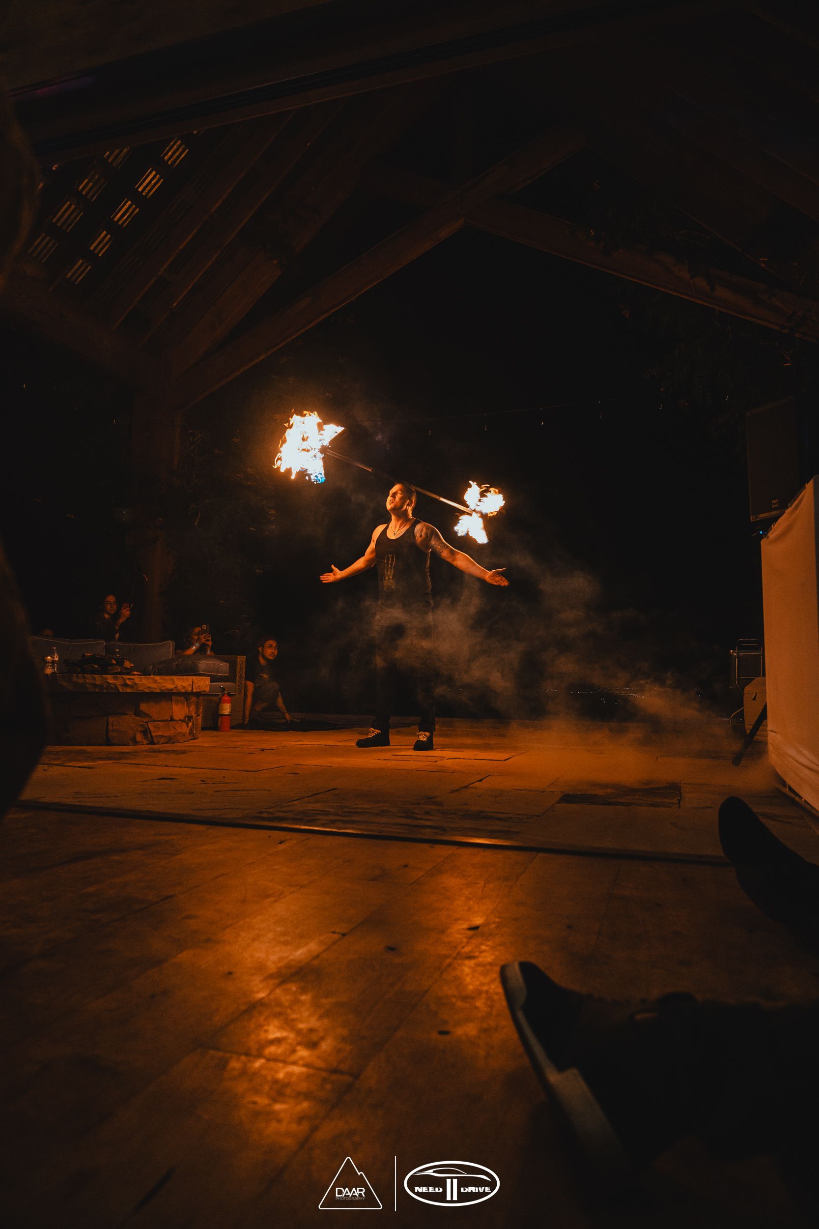 A woman is performing a fire show in a dark room.