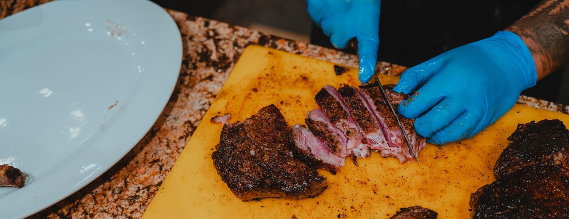 A person is cutting a piece of meat on a cutting board.