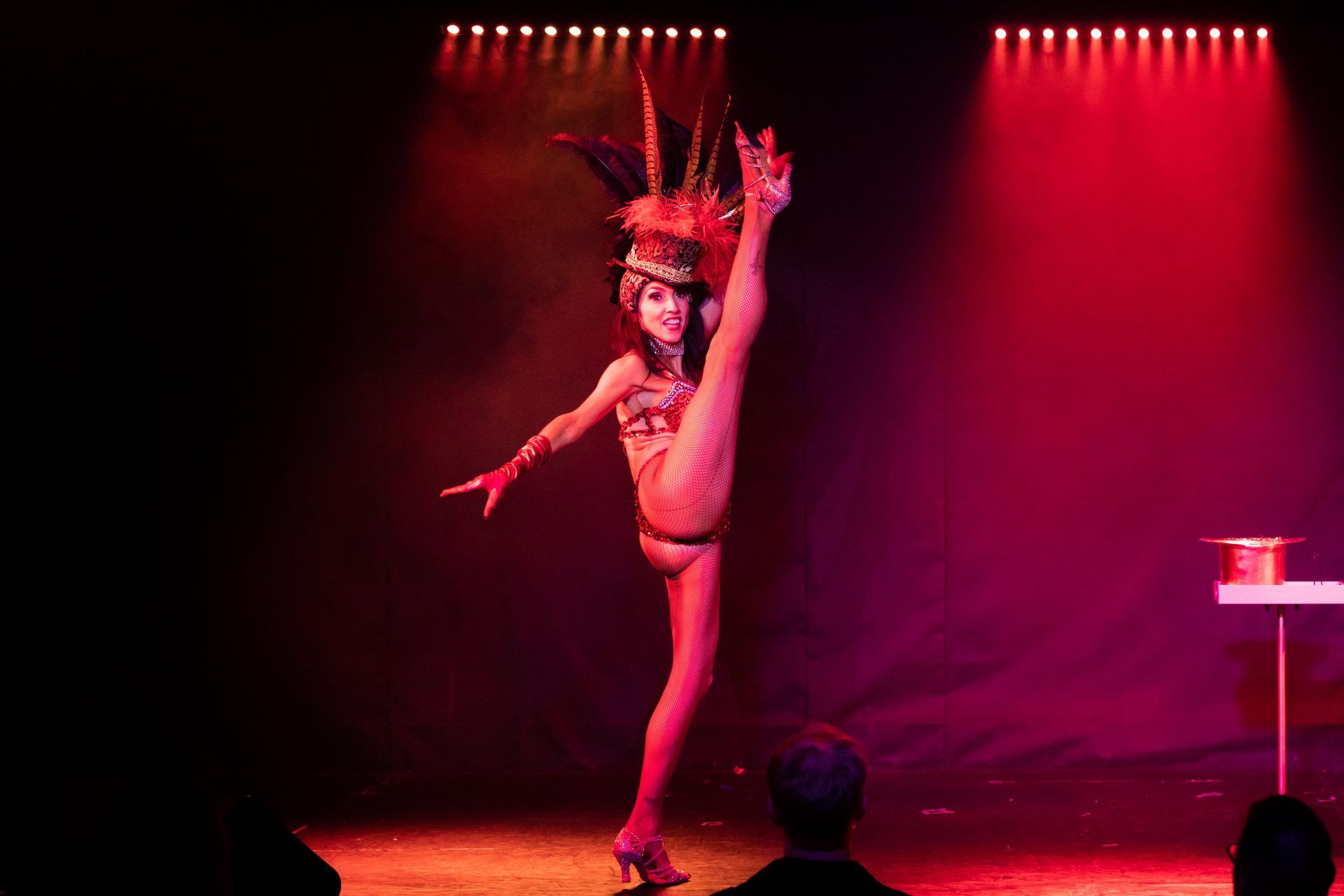 A woman is doing a split on a stage in front of a crowd.