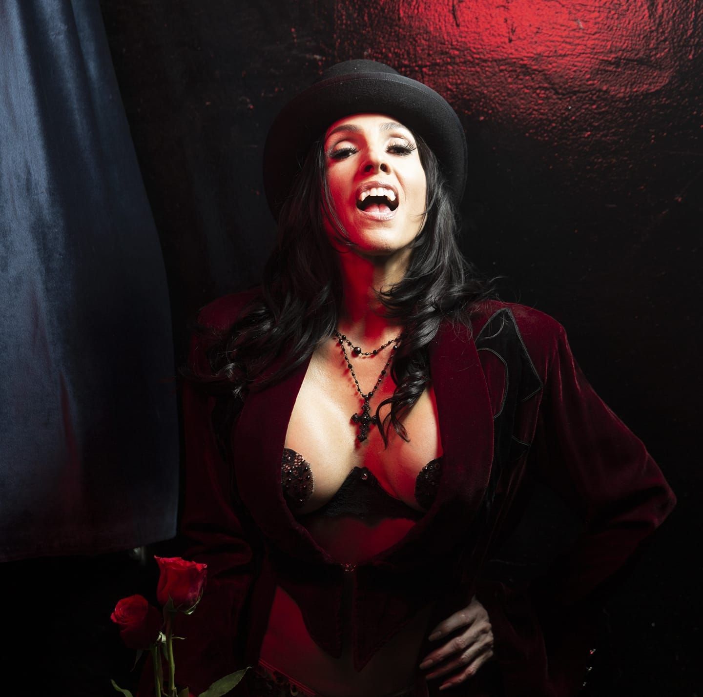 A woman wearing a hat and a bra is standing in a dark room