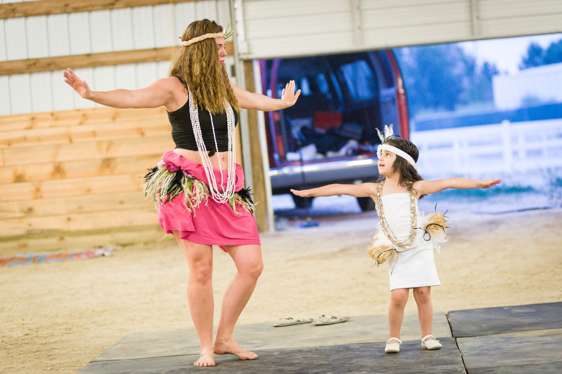 A woman and a little girl are dancing together.