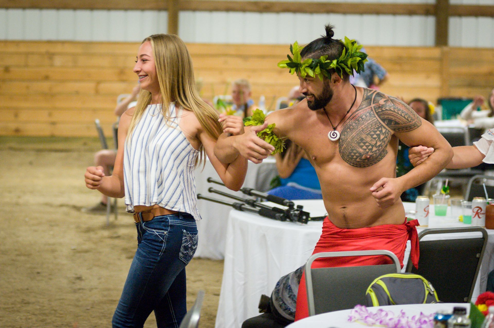 A man without a shirt is dancing with a woman.