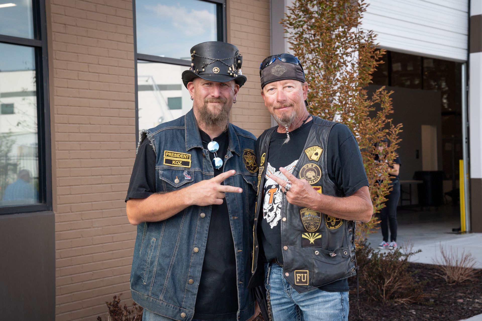 Two men are standing next to each other in front of a building.